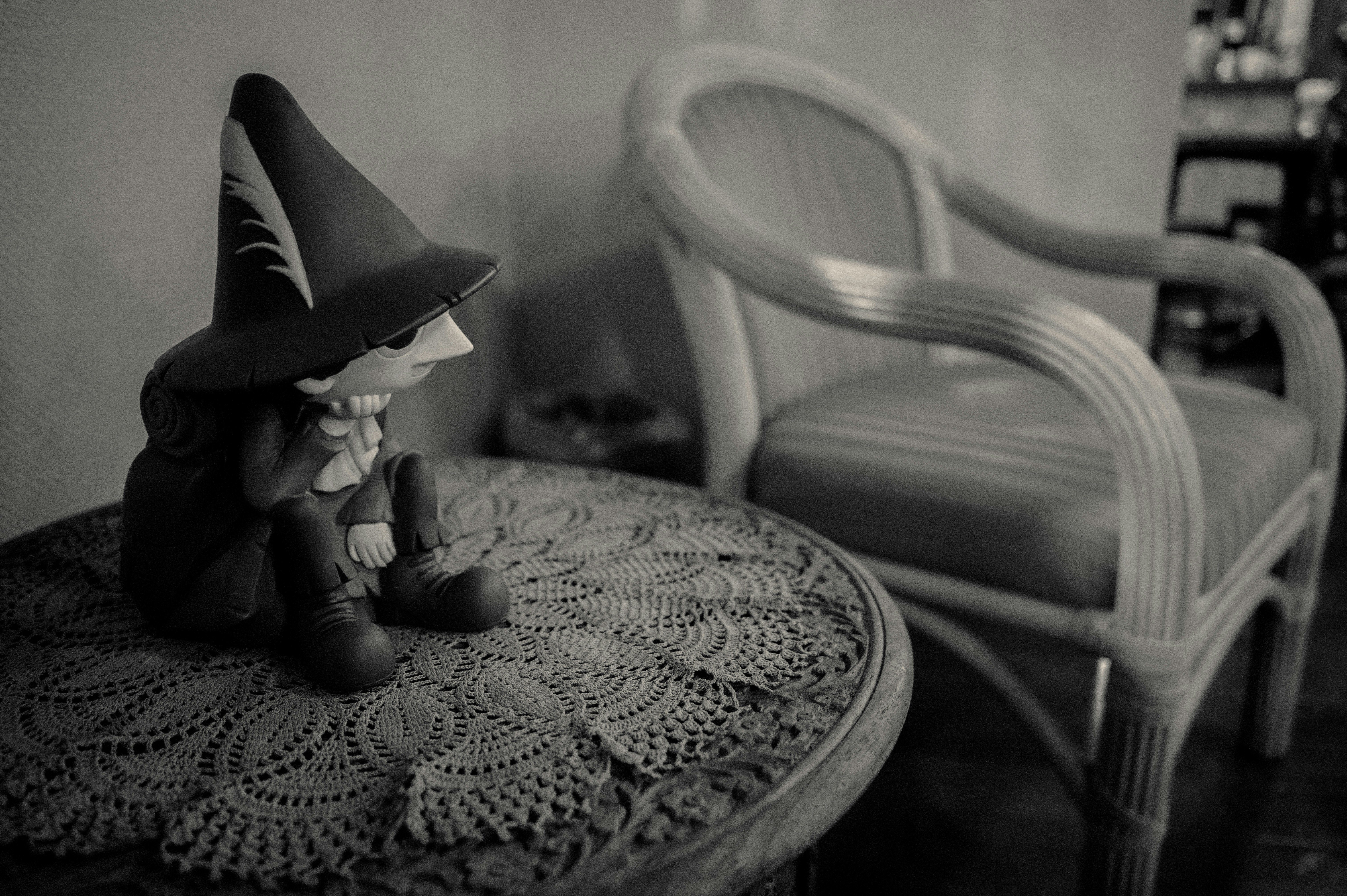 黒い帽子の魔女コスチュームを着た子どもがソファのそばで眠るように座る室内の場面