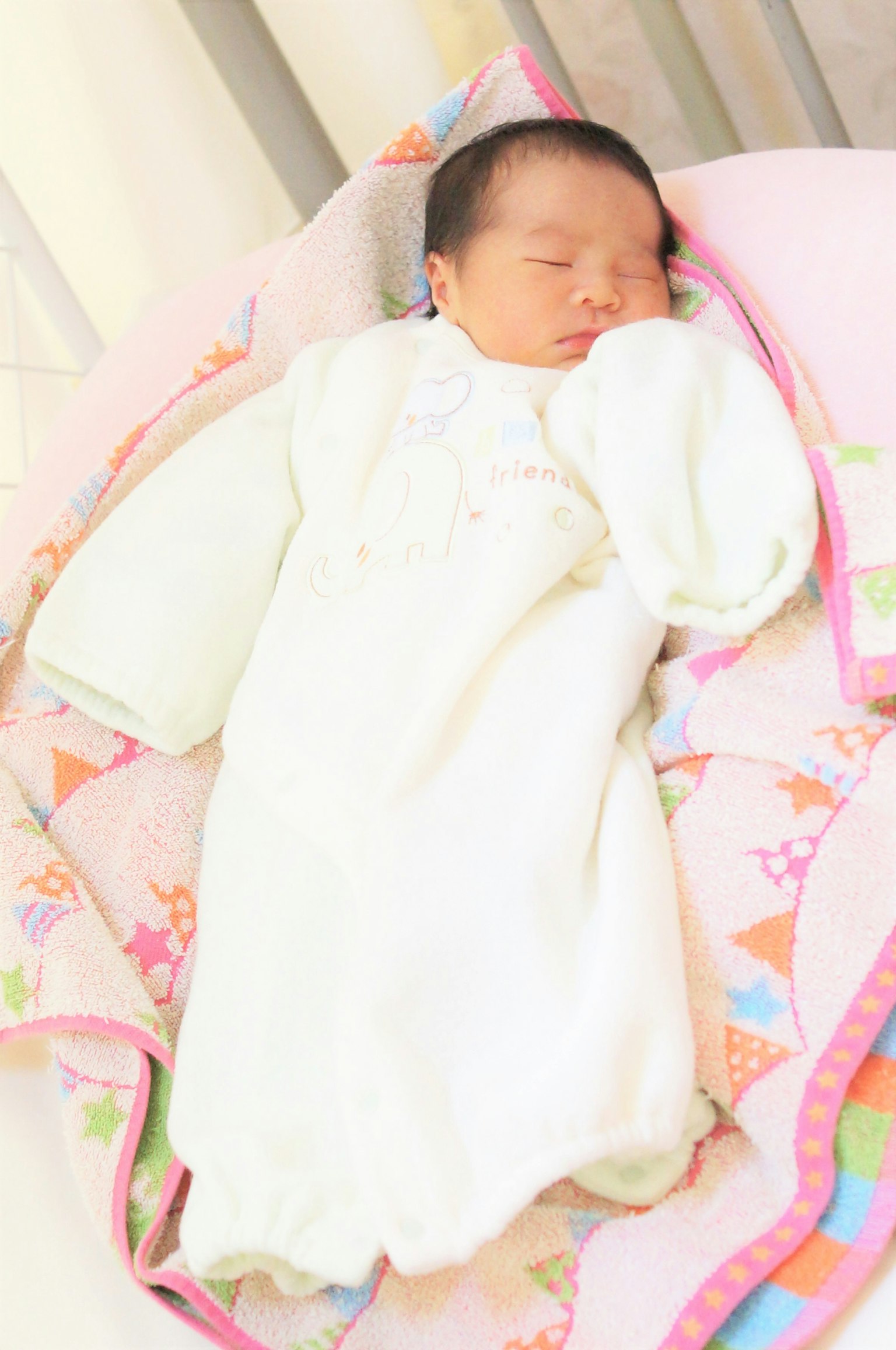 穿着白色衣服的婴儿在彩色毯子上睡觉