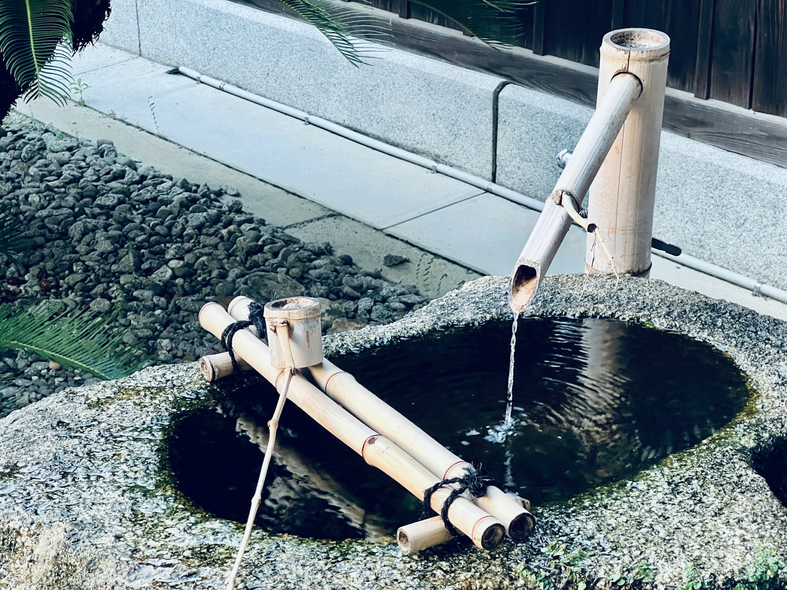 Ein Steinwasserbecken mit Bambuswasserfluss