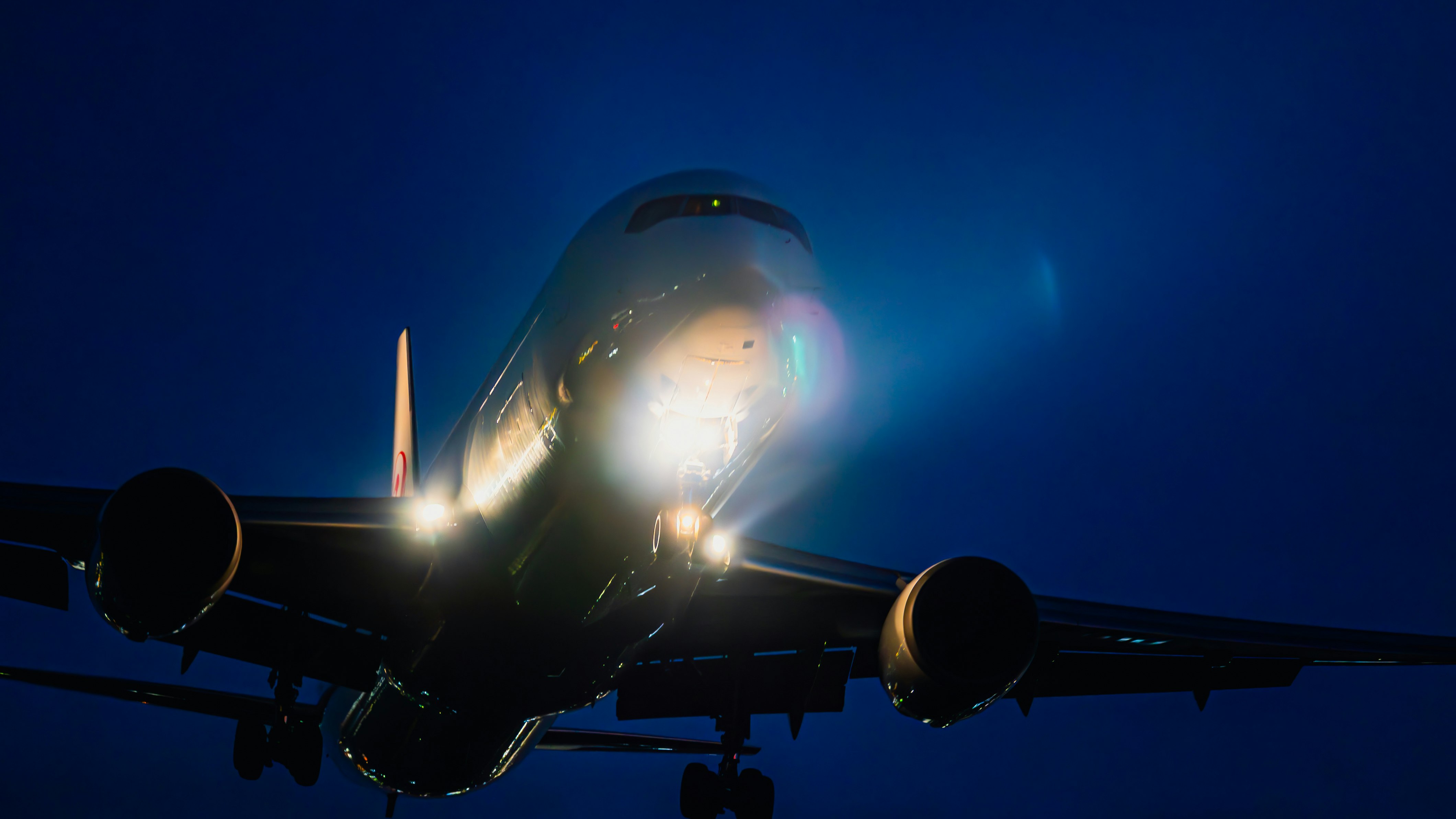 silueta frontal de un avión de pasajeros volando de noche