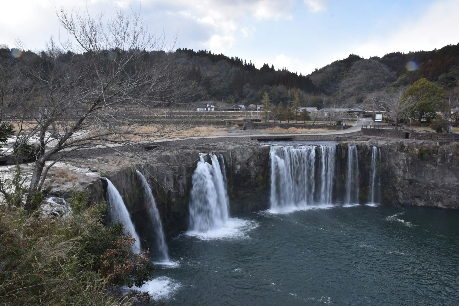 Vista panoramica di una cascata che si tuffa in un fiume tranquillo