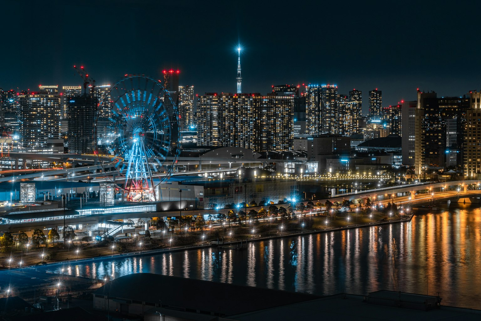 Nachtsicht auf die Skyline von Tokio mit Wolkenkratzern und einem bunten Riesenrad