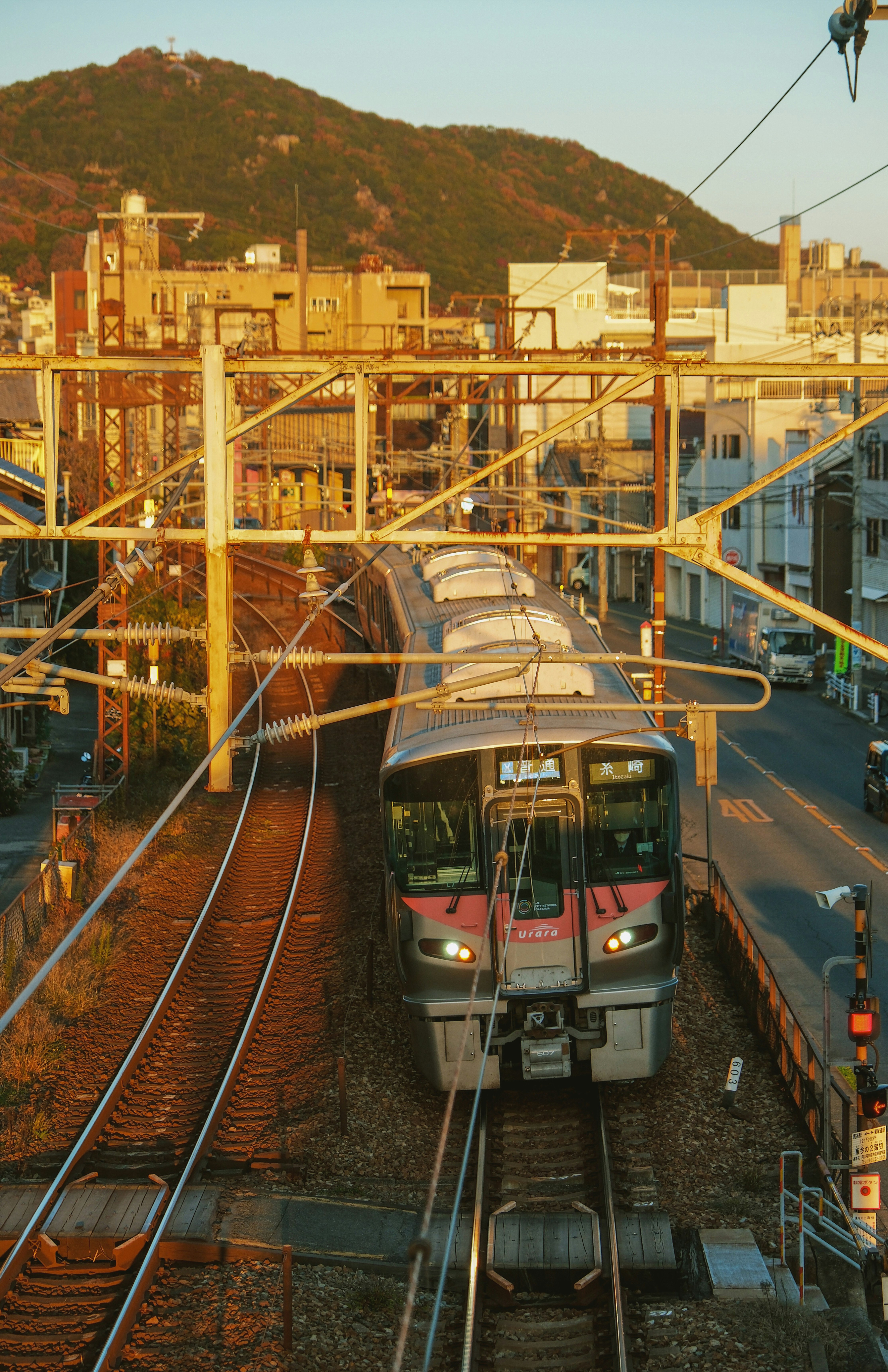 夕暮れの山並みを背景にした電車の車両基地