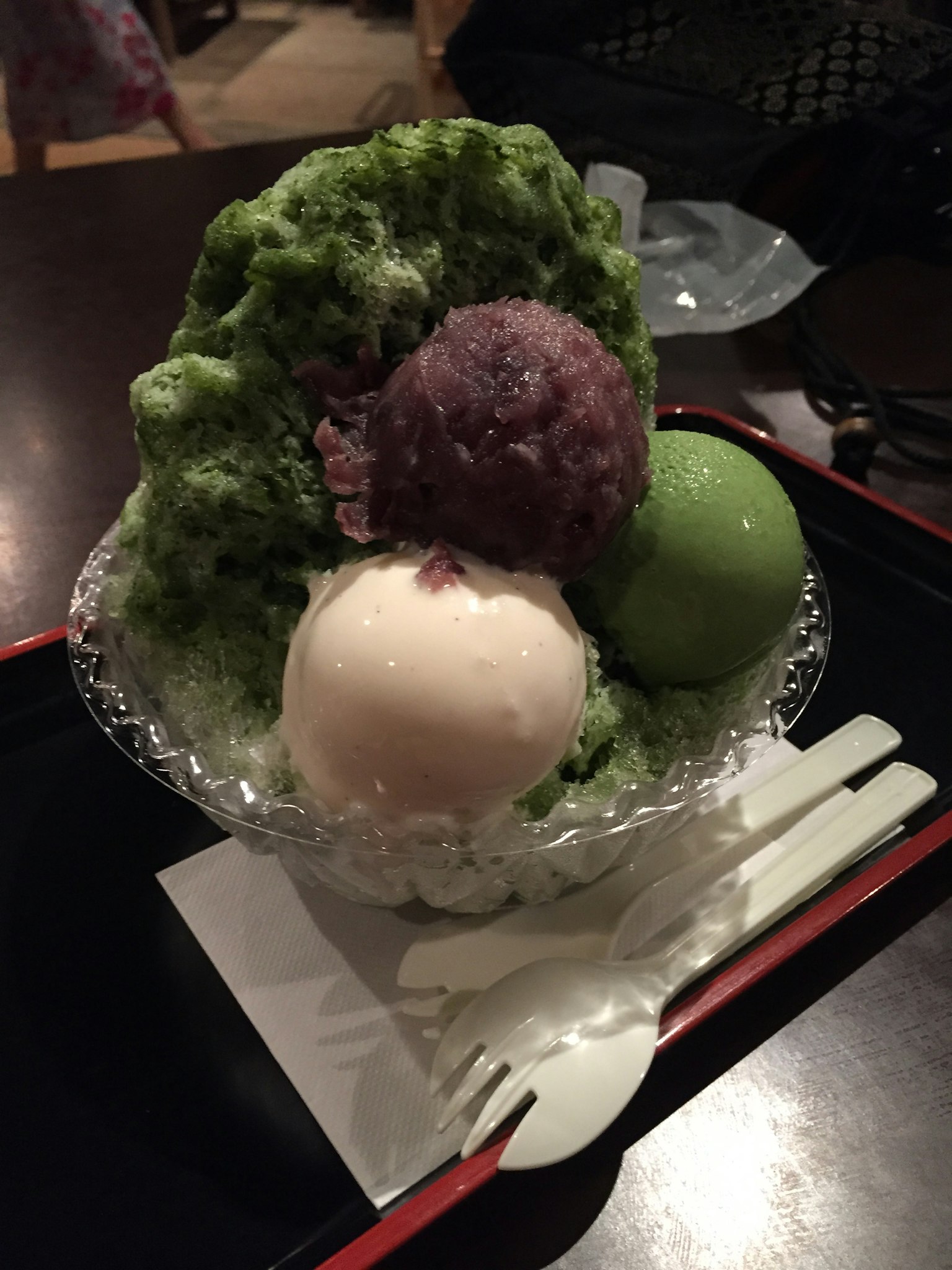 녹차 빙수 위에 아이스크림과 팥이 얹힌 디저트