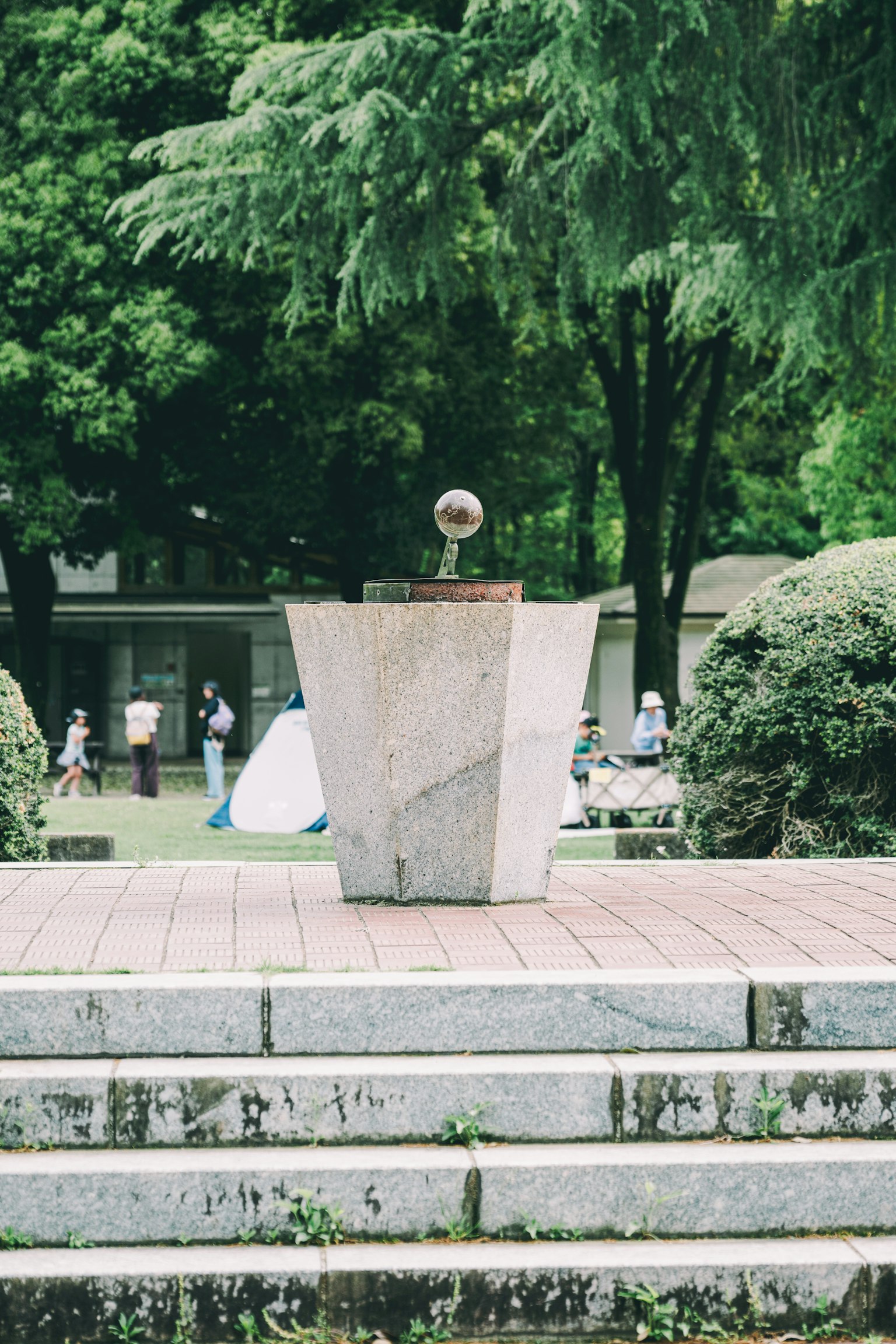 公園中央的現代雕塑，周圍環繞著綠色樹木