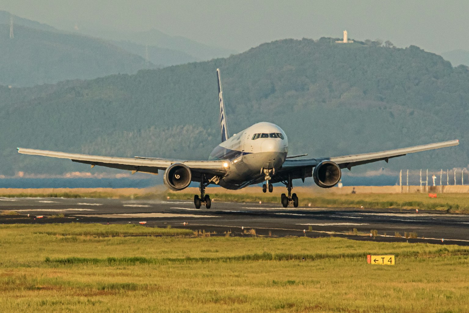 Flugzeug landet auf der Landebahn mit Bergen im Hintergrund