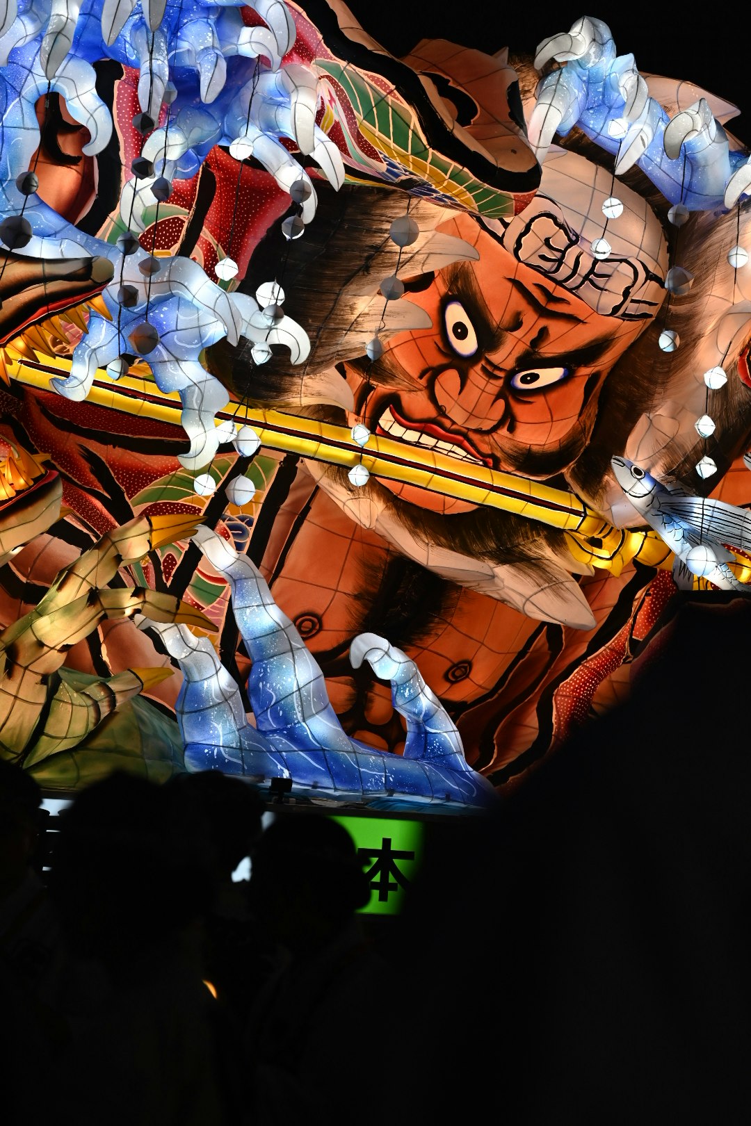 色鮮やかな仮面と人形が並ぶ祭りの舞台のような光景