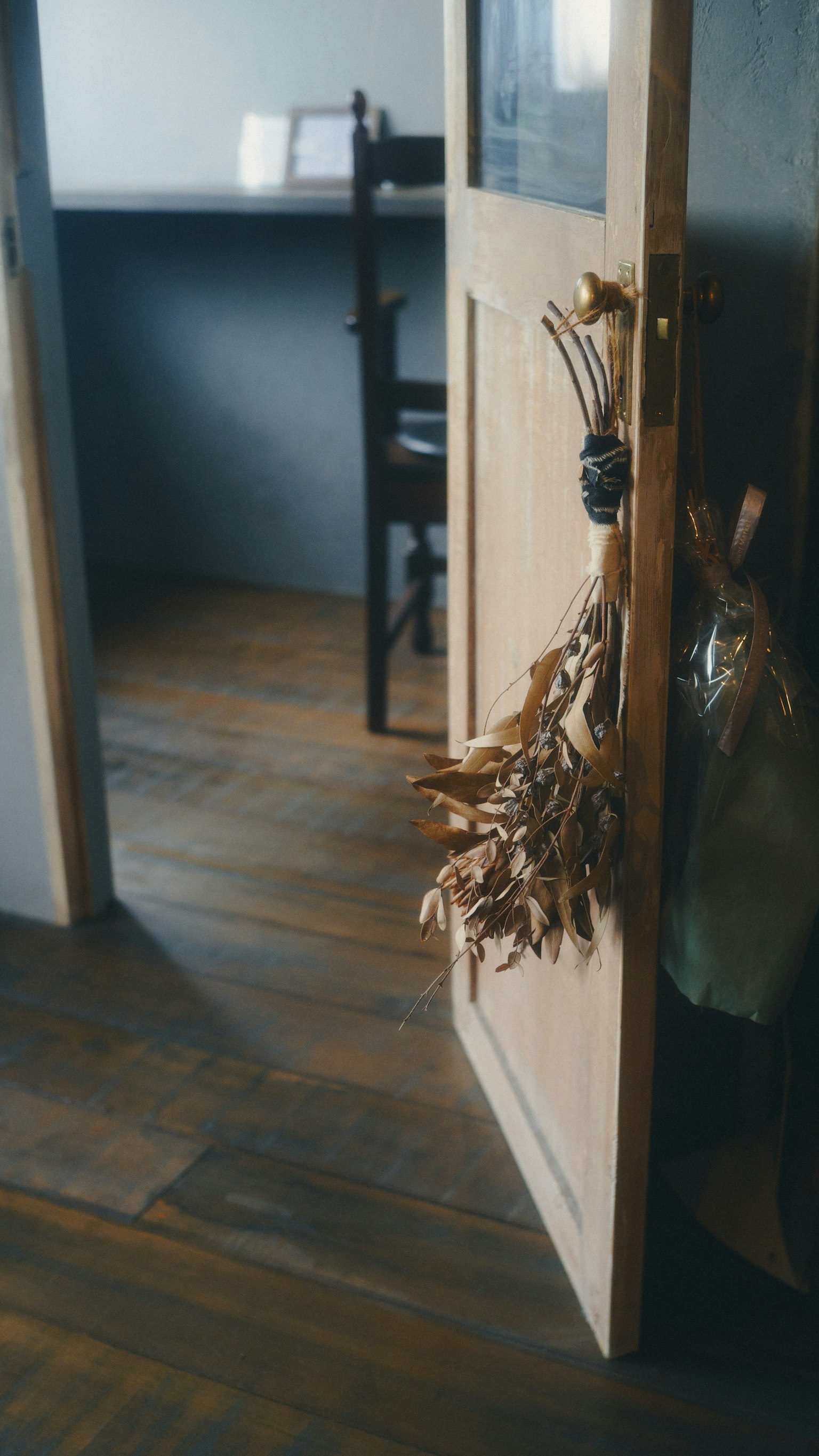 Interior de una habitación con una puerta abierta que revela un suelo de madera y una silla