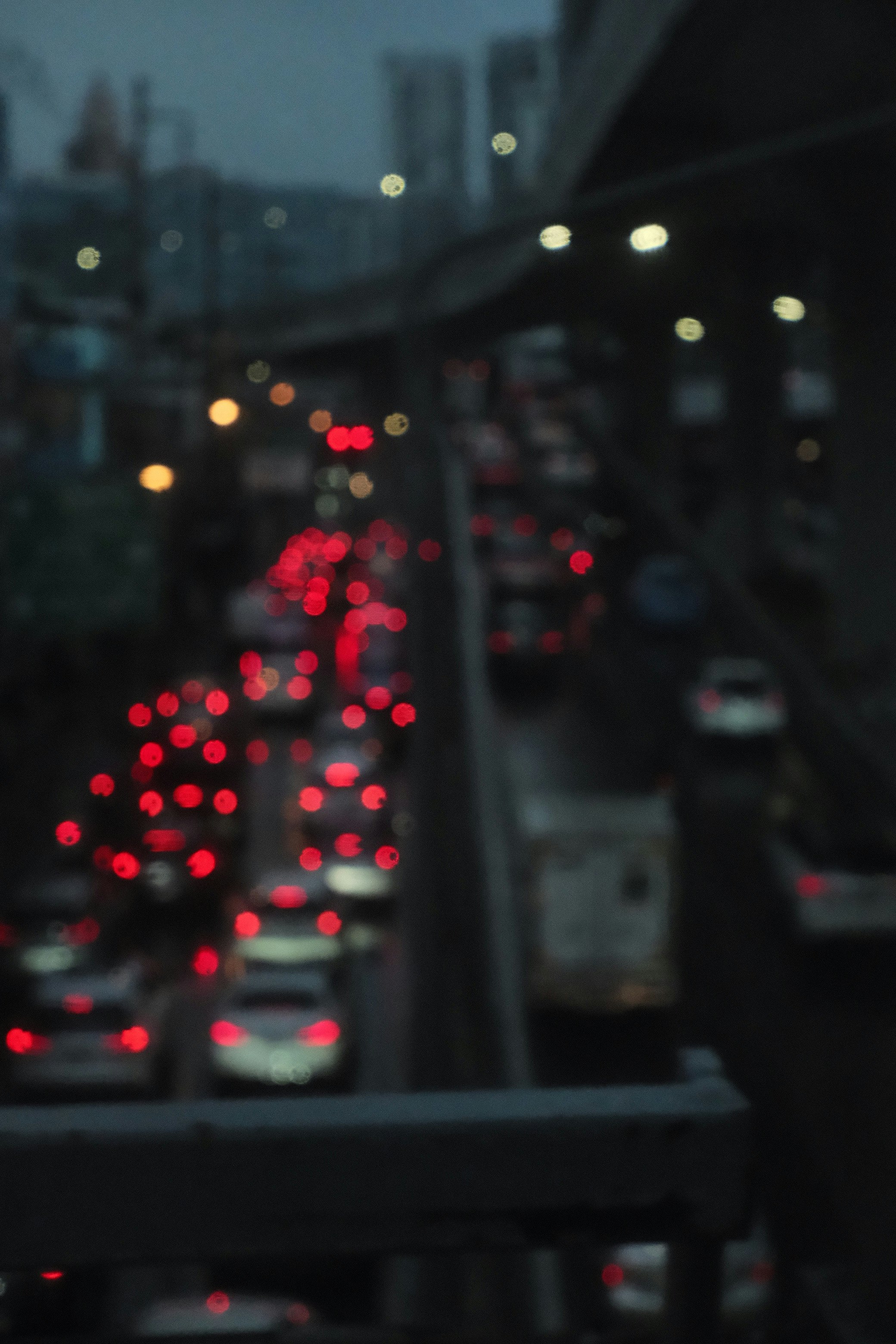 夜の高速道路で流れる車のテールライトのボケ