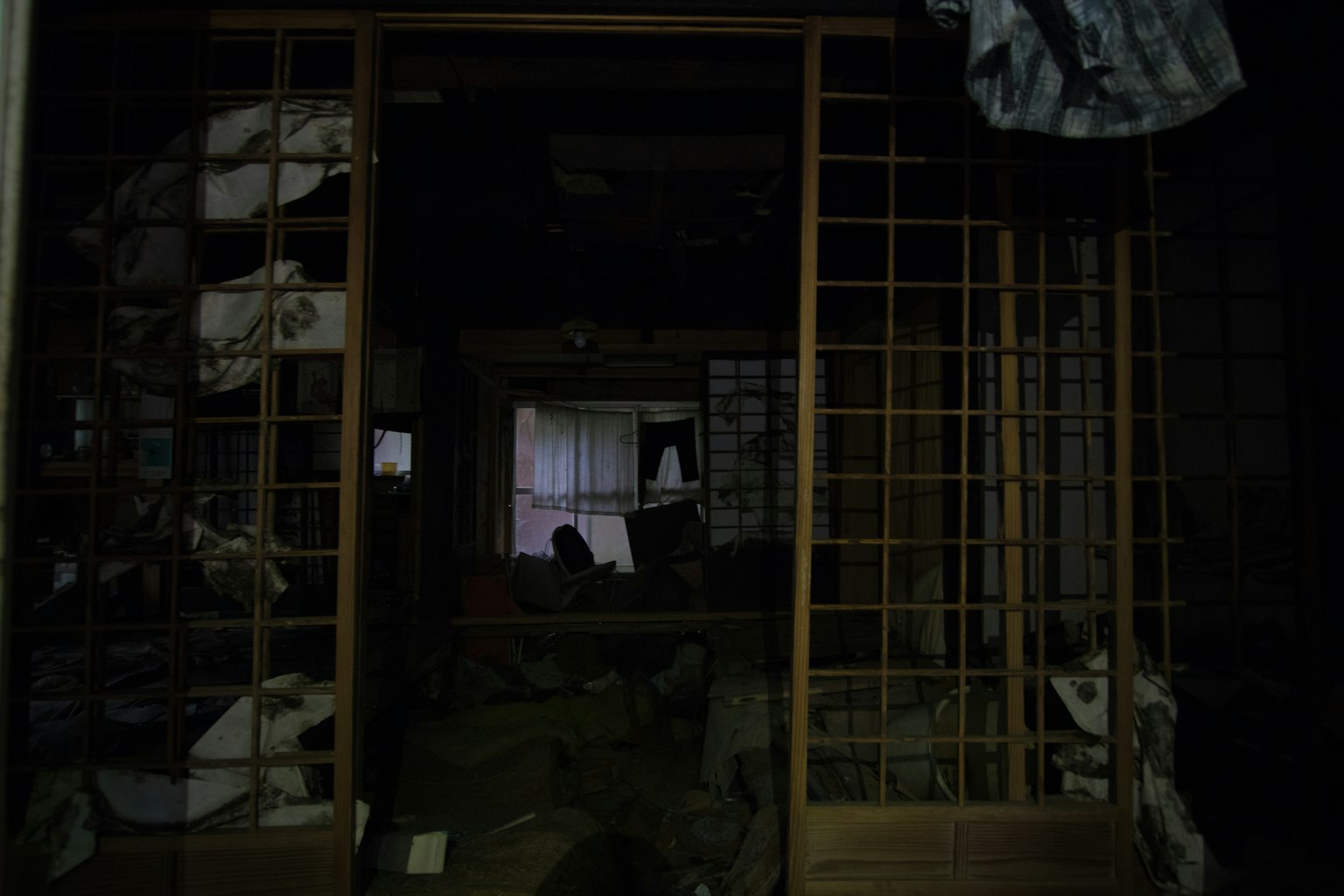 Un corridoio poco illuminato con schermi shoji giapponesi tradizionali