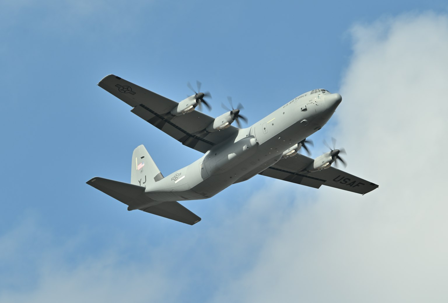 Large transport aircraft flying overhead with visible propellers