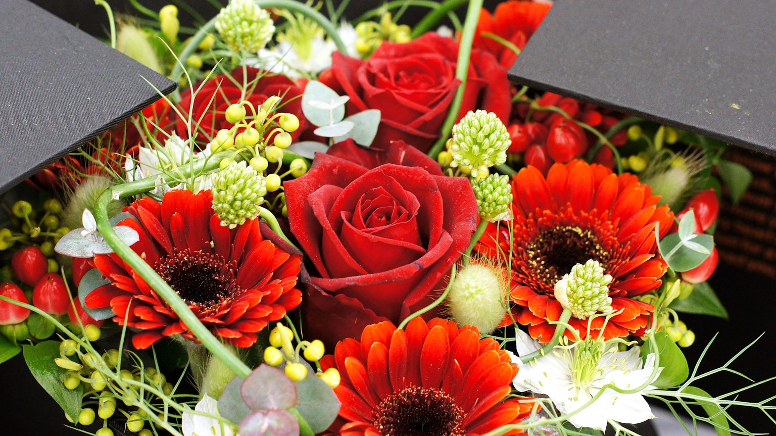 Magnifique bouquet avec des roses rouges et des fleurs orange