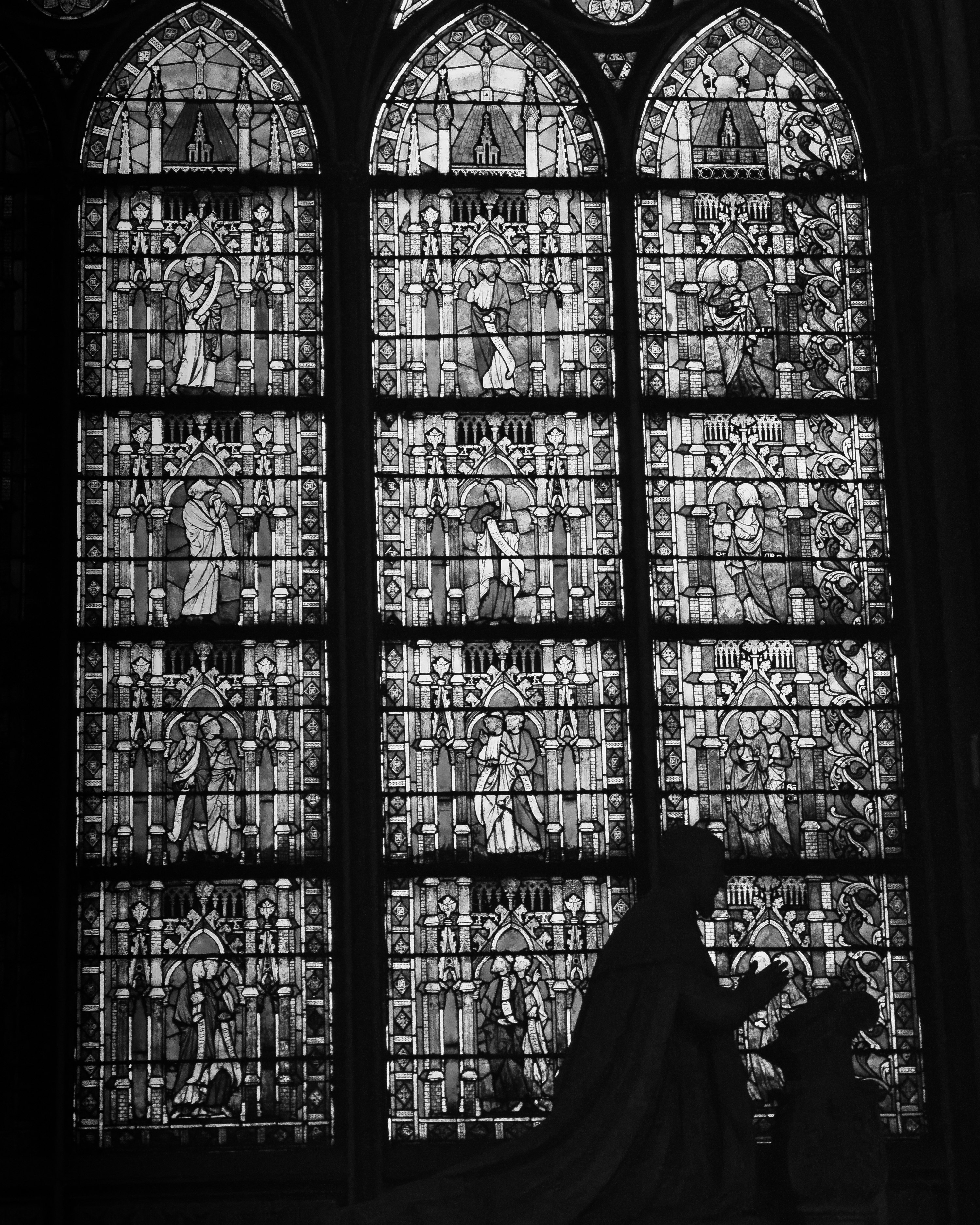 vitraux d’une grande fenêtre et silhouette dans une église