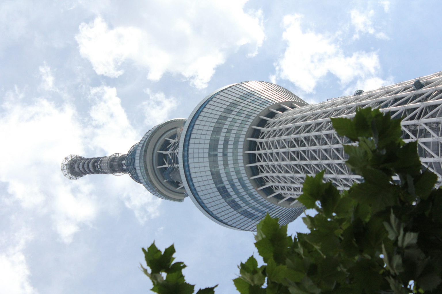 Pemandangan Tokyo Skytree dari bawah dengan latar belakang langit biru dan awan