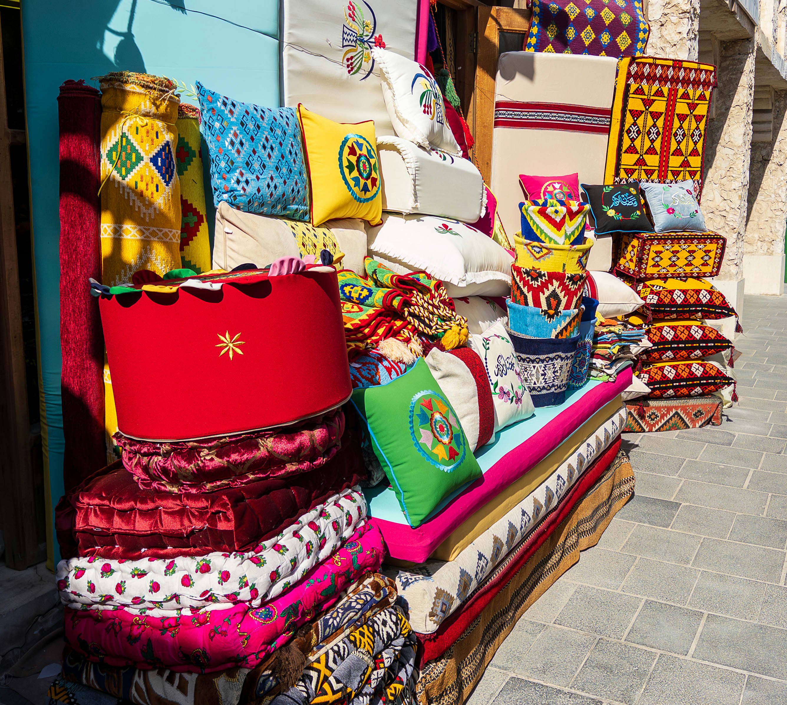 coussins colorés et textiles exposés devant une boutique