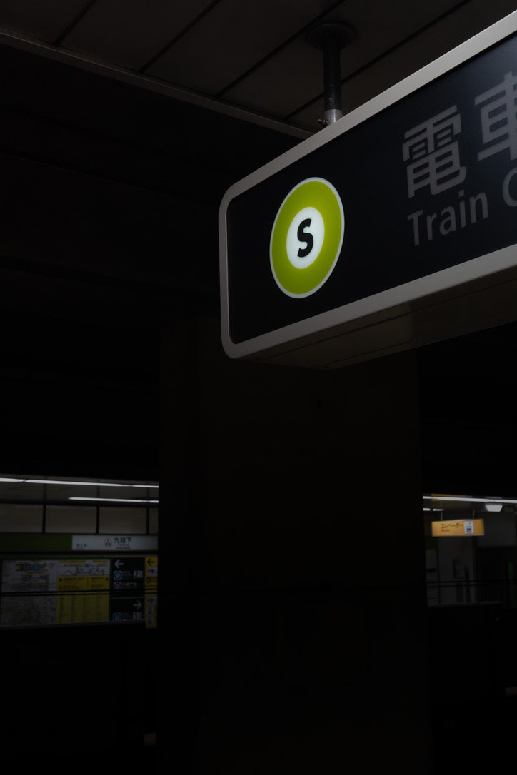 駅のホームで「Train 5」表示の案内板が光る画像