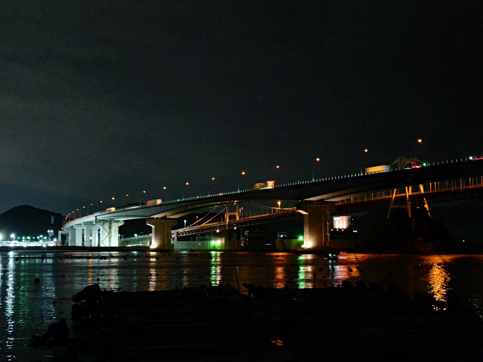 Schöne Aussicht auf eine Brücke bei Nacht mit Reflexionen im Wasser