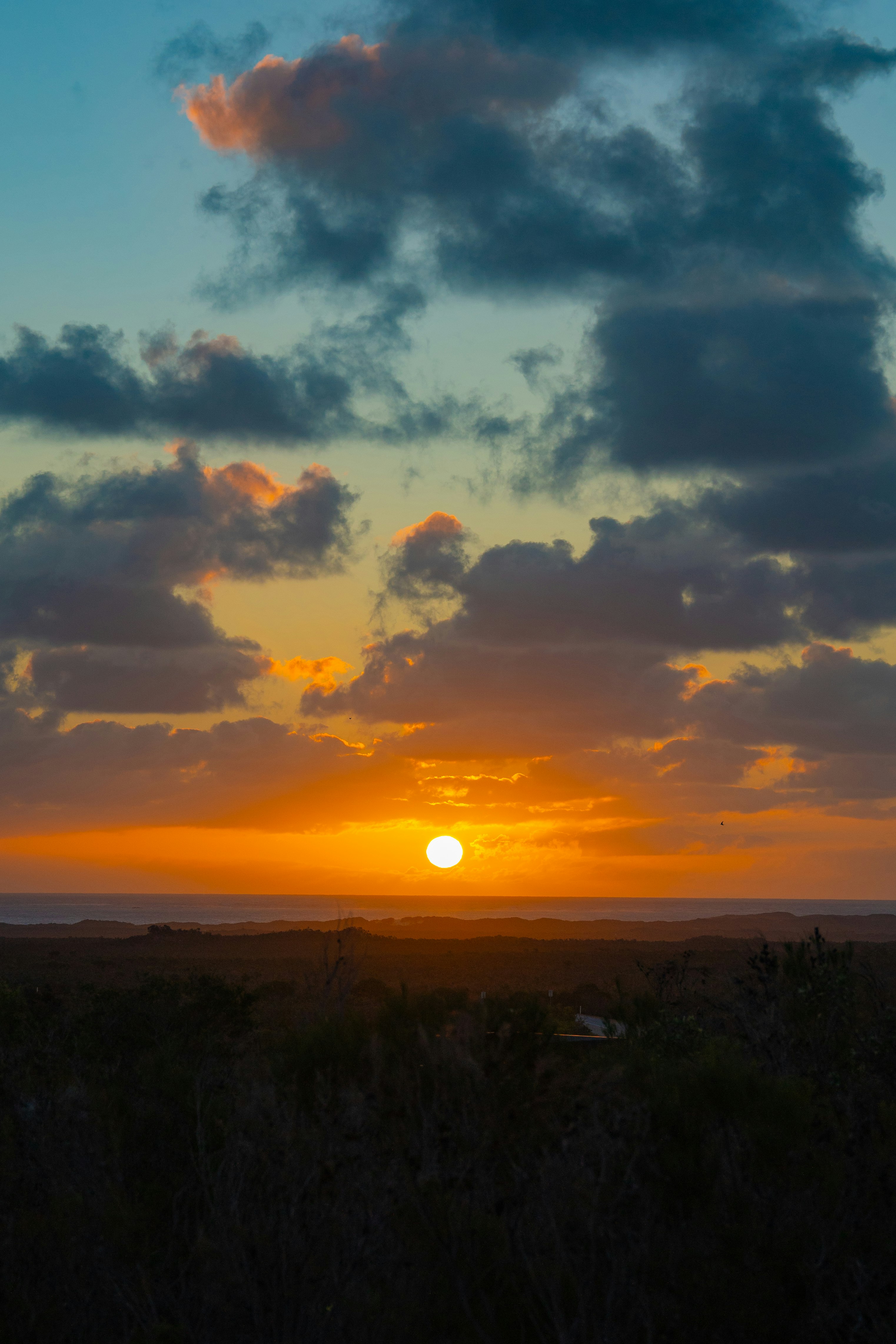 sun setting over the sea with dramatic clouds