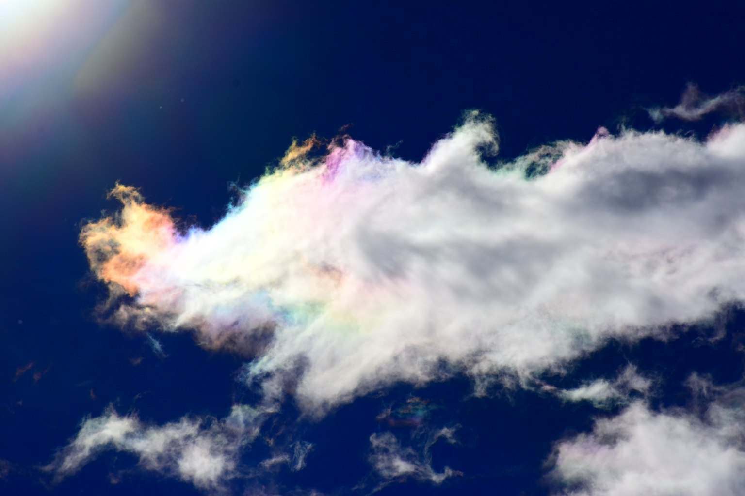 Regenbogenfarbige Wolke schwebt in einem blauen Himmel