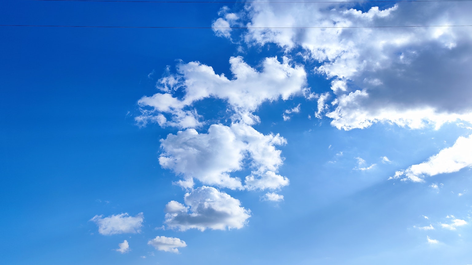 Un paisaje con nubes blancas flotando en un cielo azul