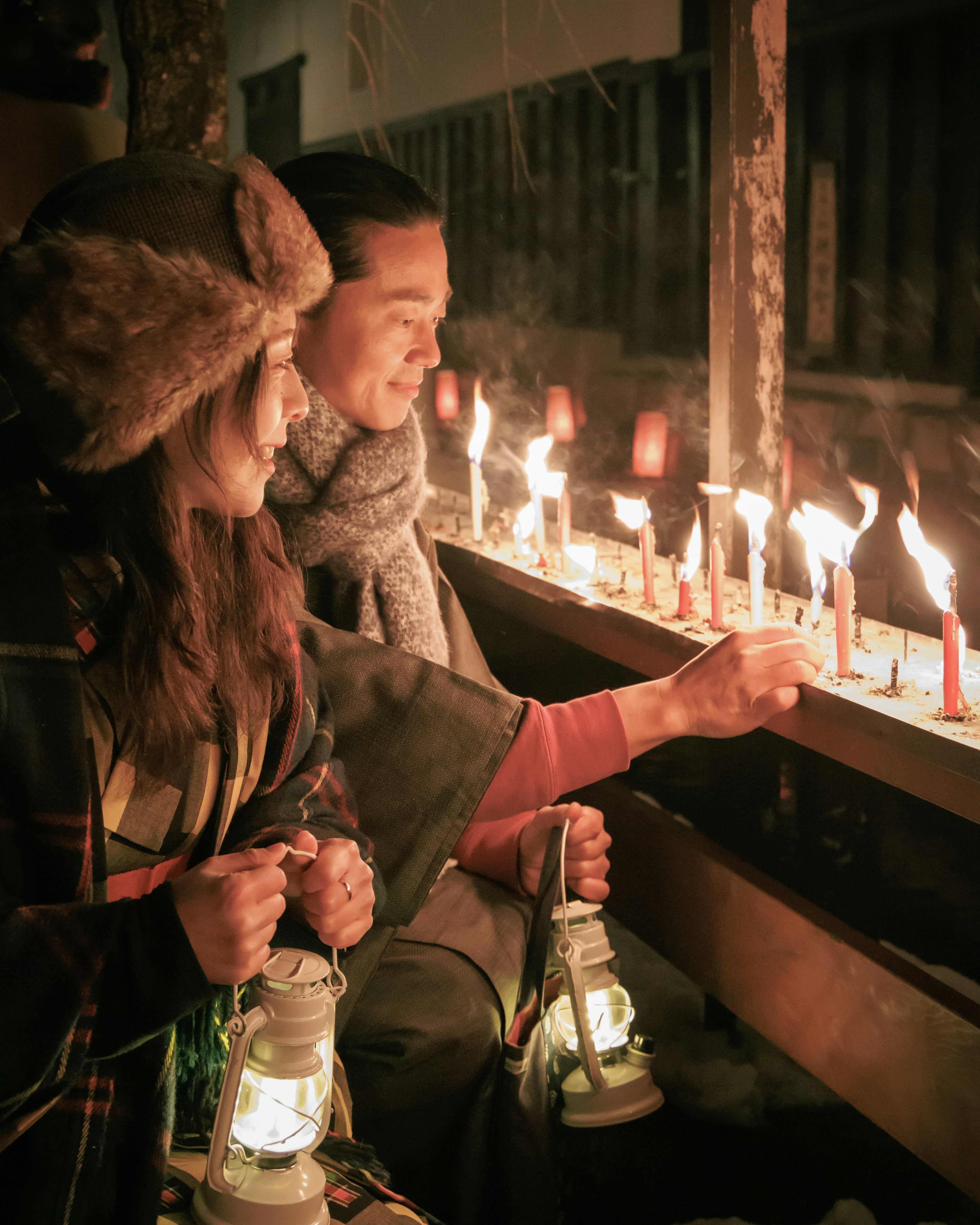 people praying with candles lit in front of them