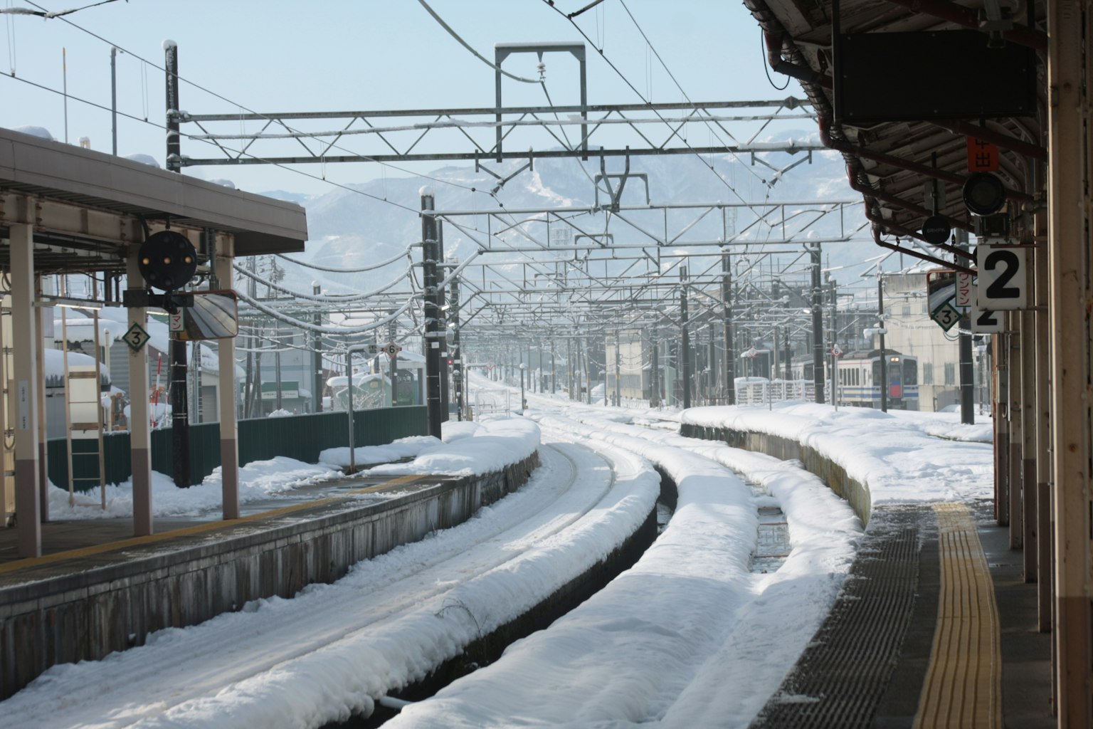 Plateforme de train et rails recouverts de neige