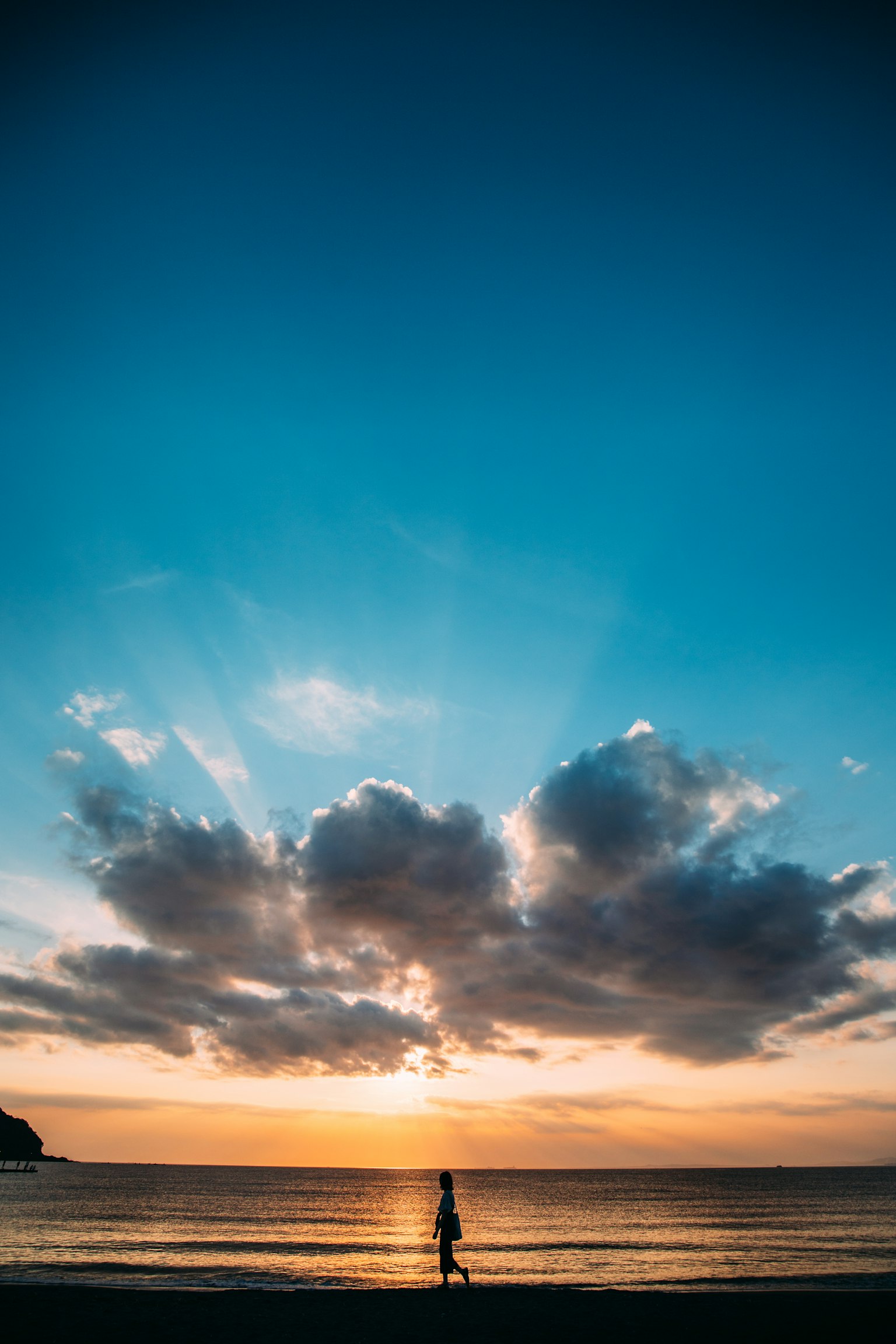 夕阳下在海滩上散步的人影