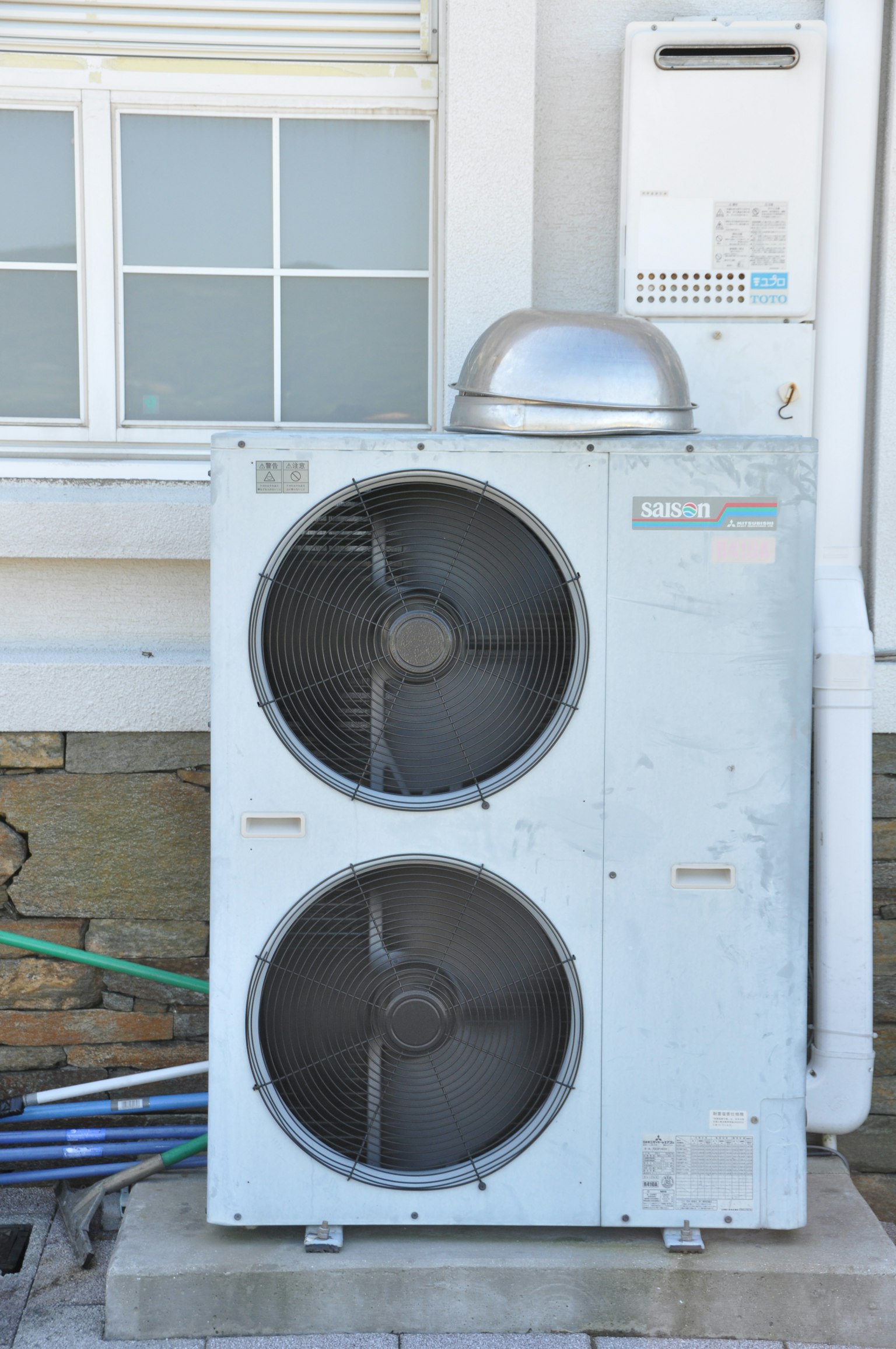 Unité extérieure d'un système de climatisation avec deux ventilateurs et un couvercle en métal
