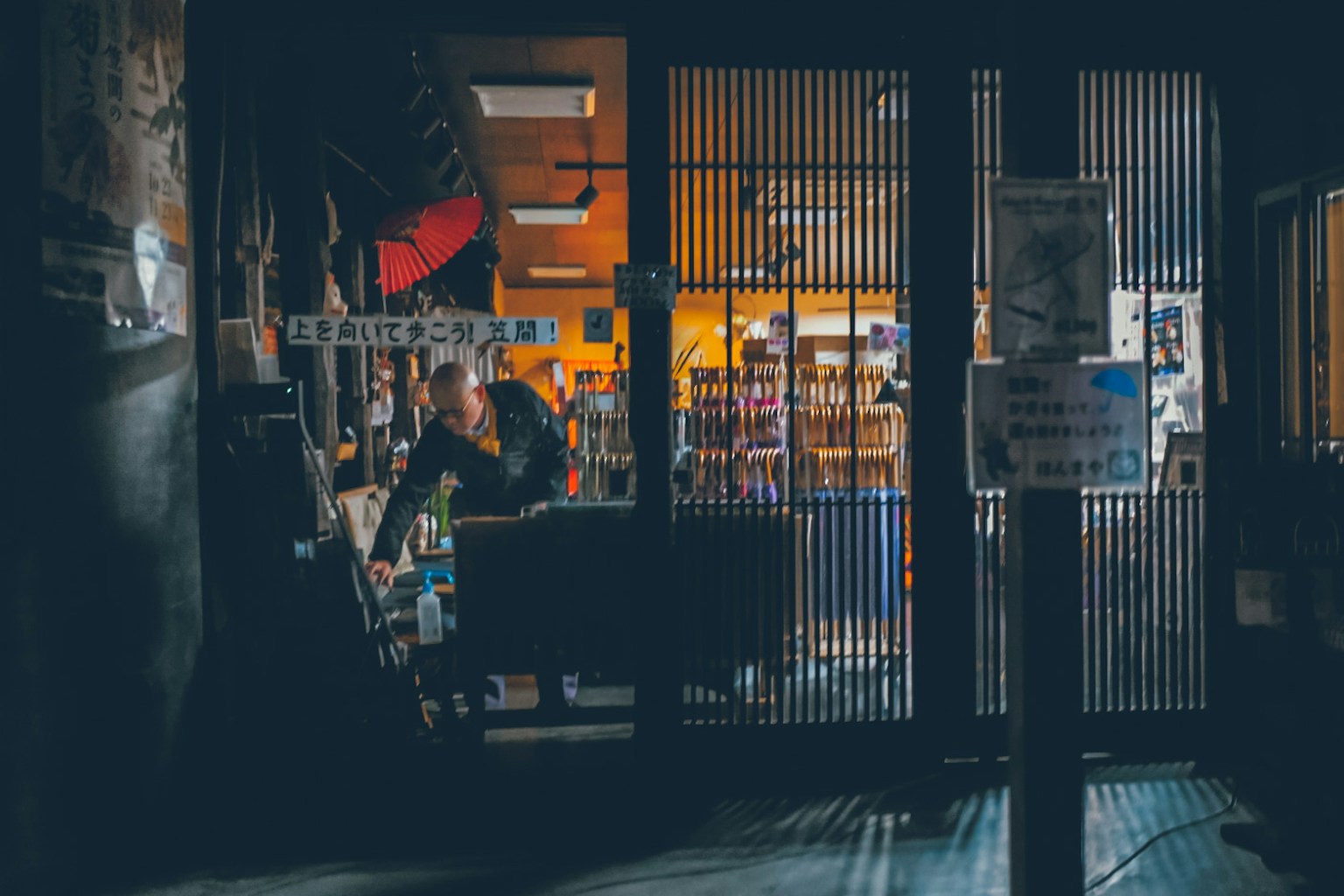 一个人在昏暗的书店内工作，书架清晰可见