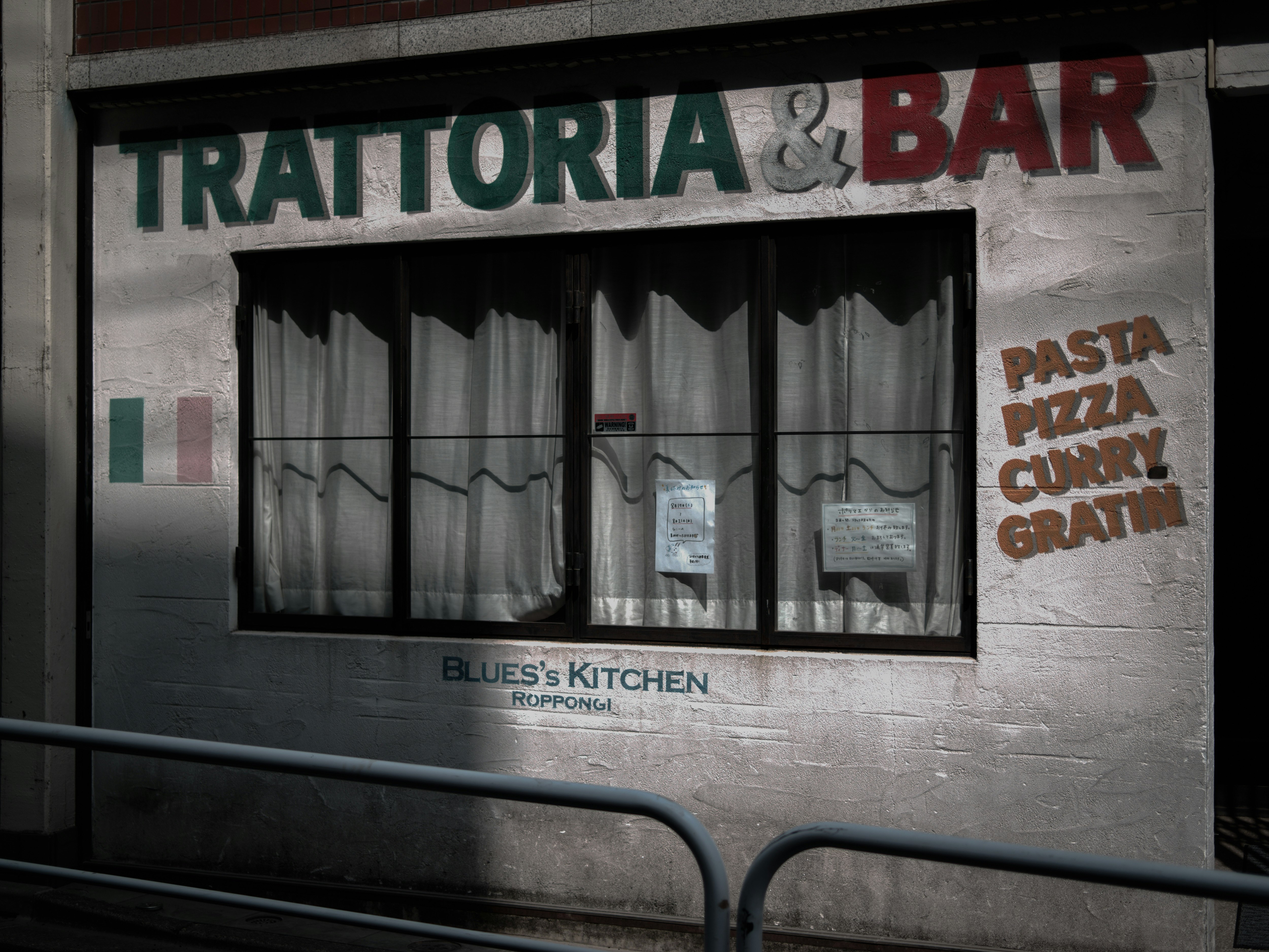 toko di gang dengan papan bertuliskan “TRATTORIA & BAR”
