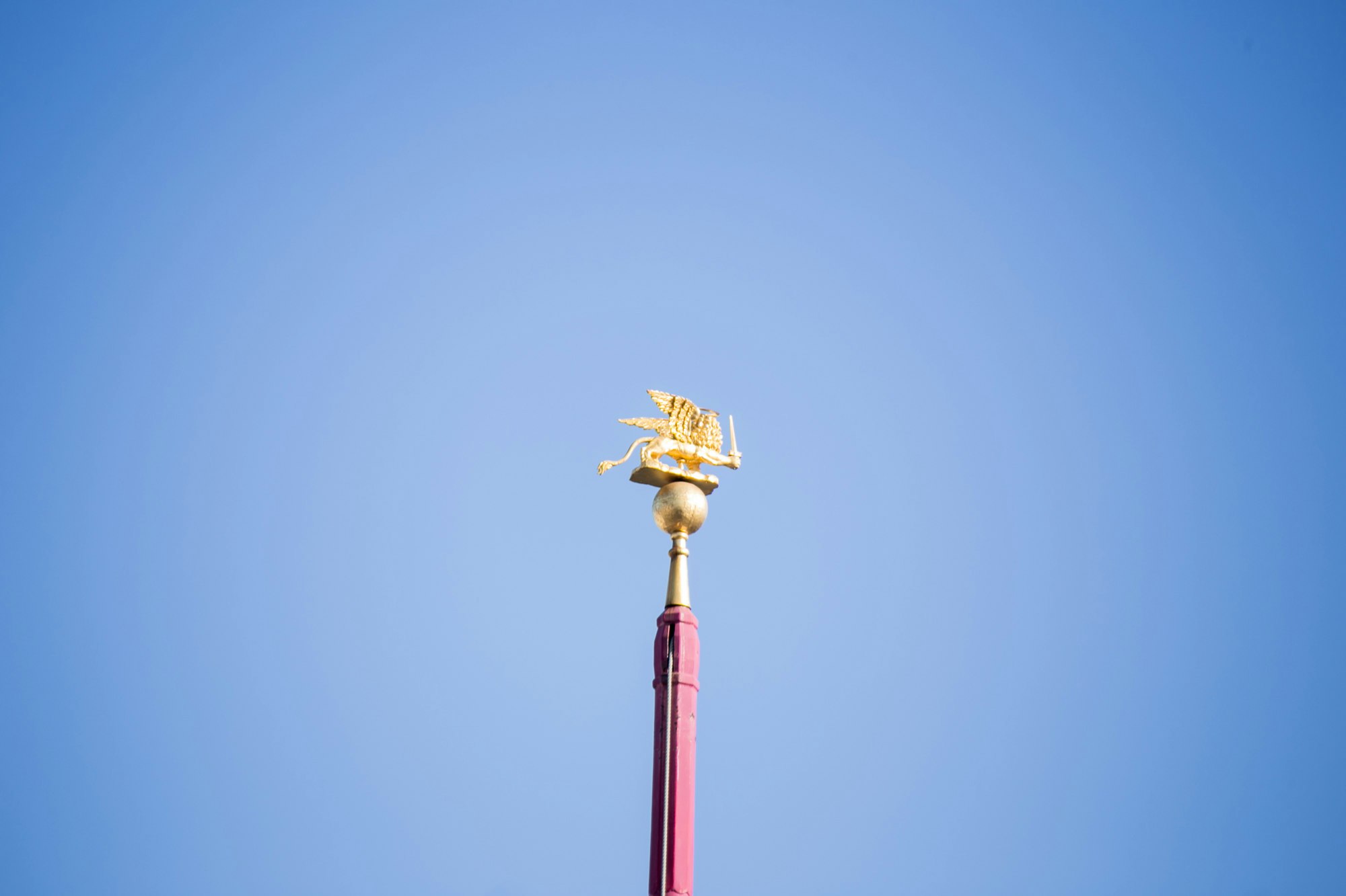 golden tower finial against a clear blue sky