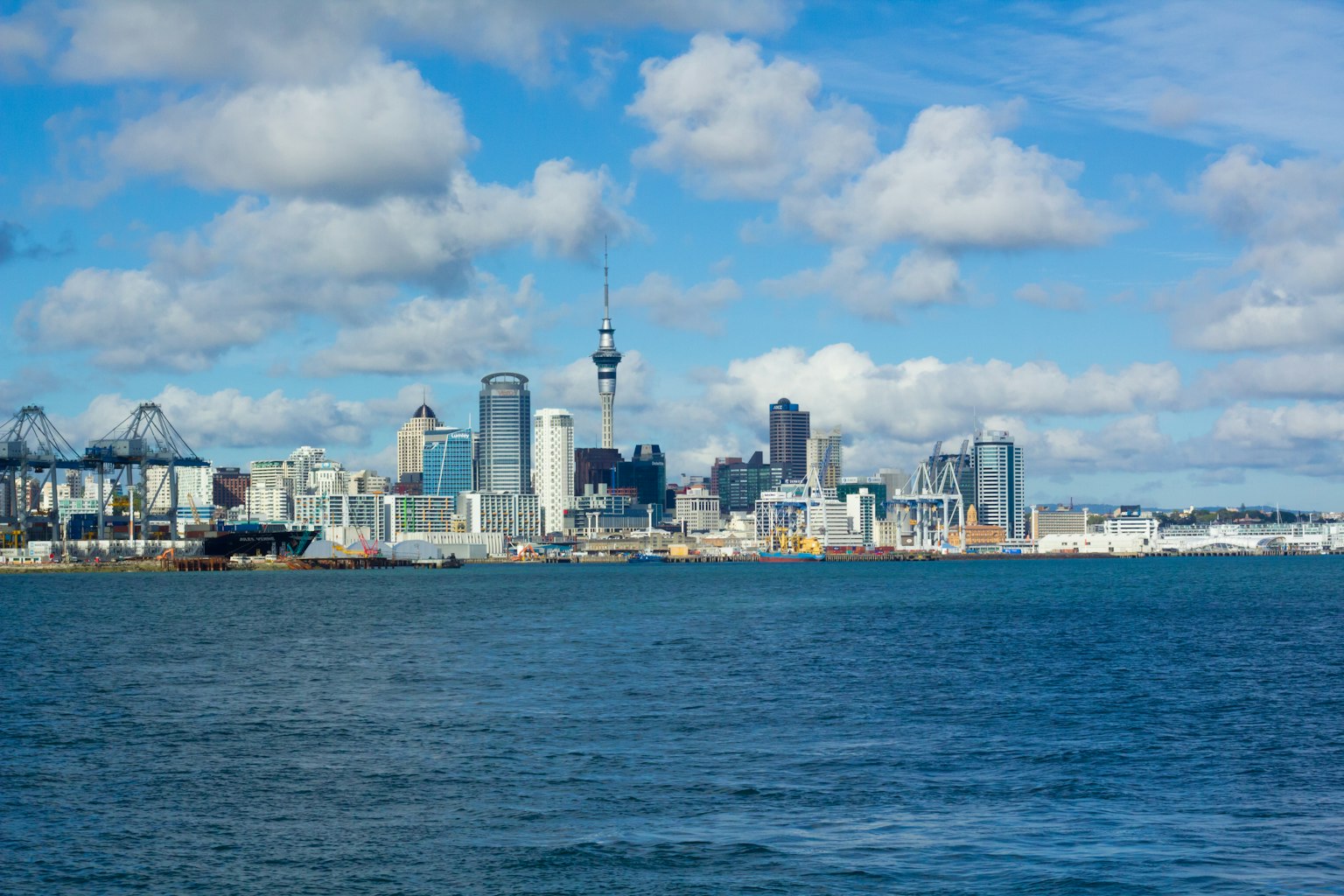 Küstenansicht von Auckland mit der Skyline und dem Sky Tower unter einem blauen Himmel