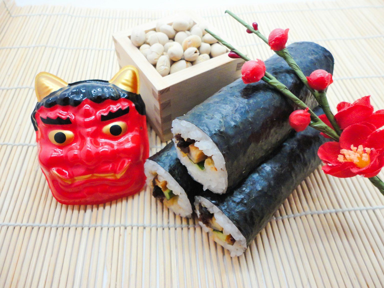Traditionelle japanische Dekoration mit rotem Dämonenmaske und Sushi-Rollen