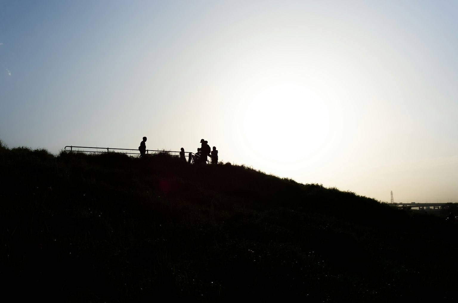 Silhouette de personnes sur une colline avec un coucher de soleil en arrière-plan