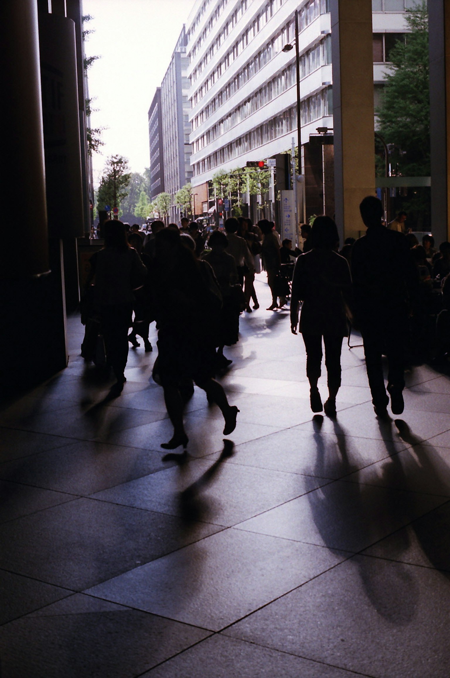 Silhouettes of people walking in an urban street