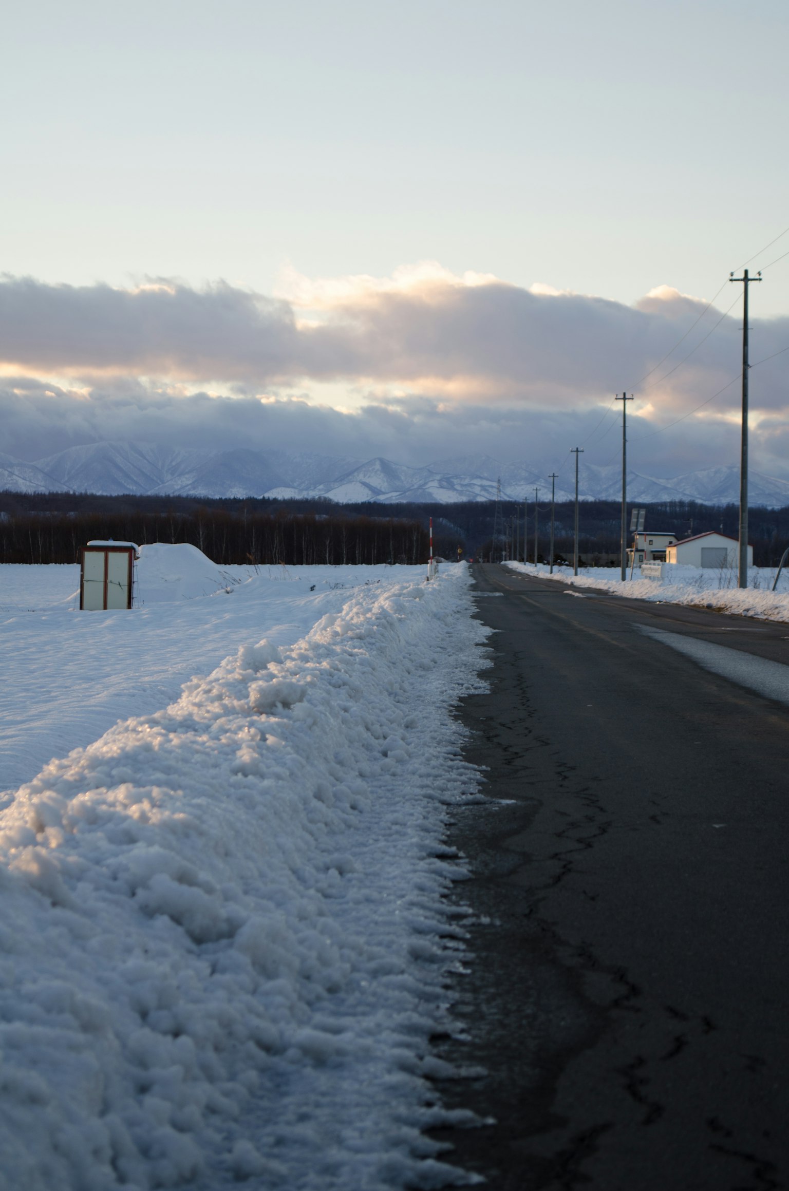 Snow-covered road with low clouds in the background