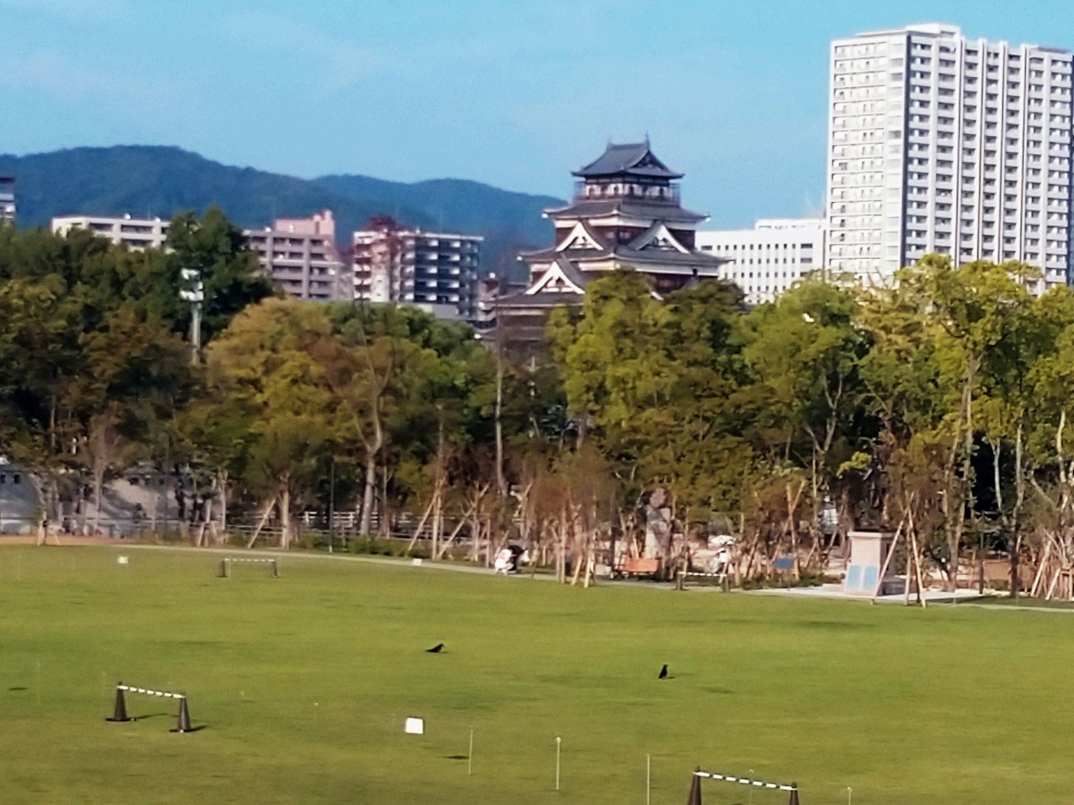 緑豊かな公園と近代的な建物の背景にある伝統的な城