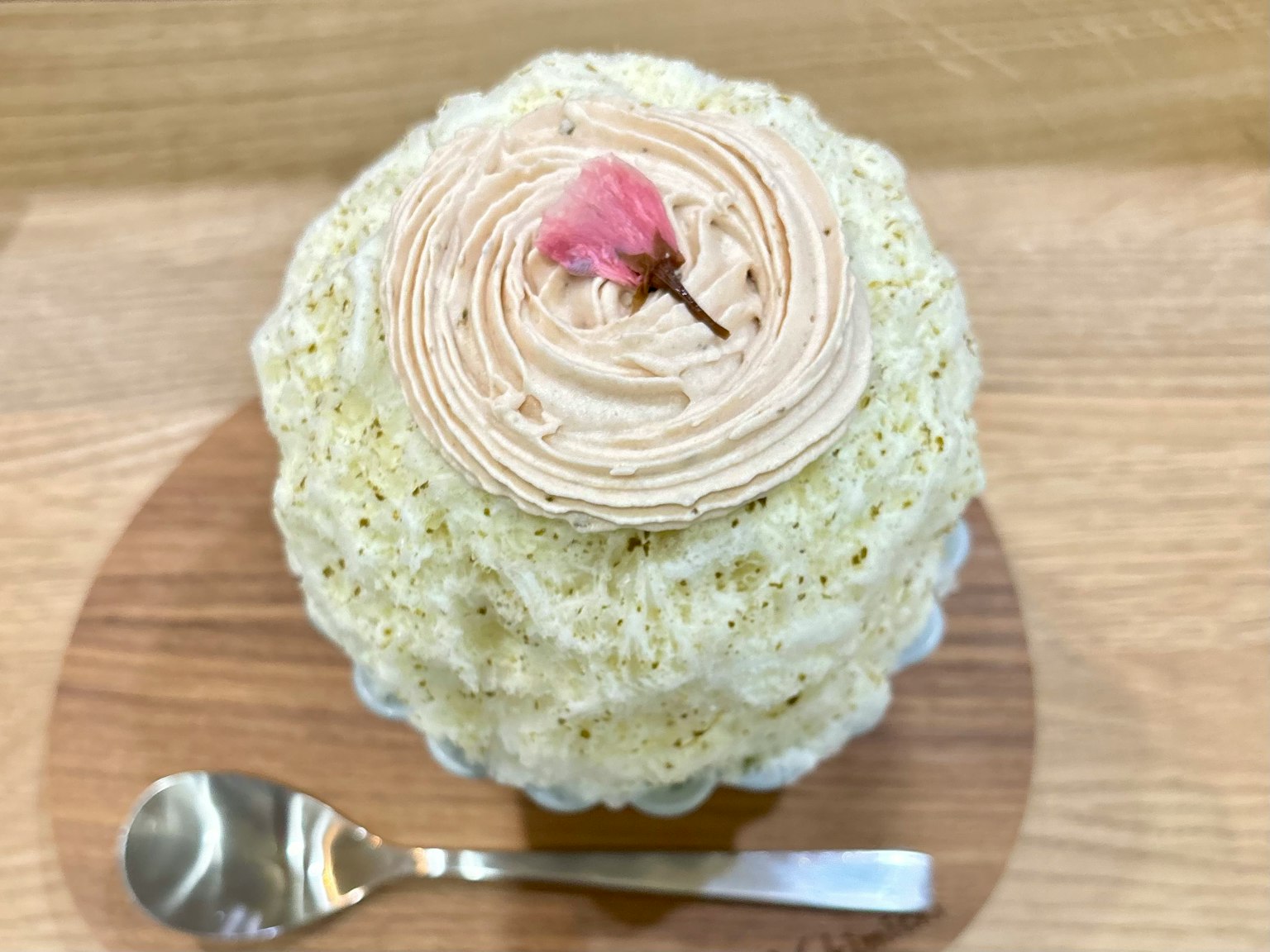 A creamy cake topped with a beautiful cherry blossom flower