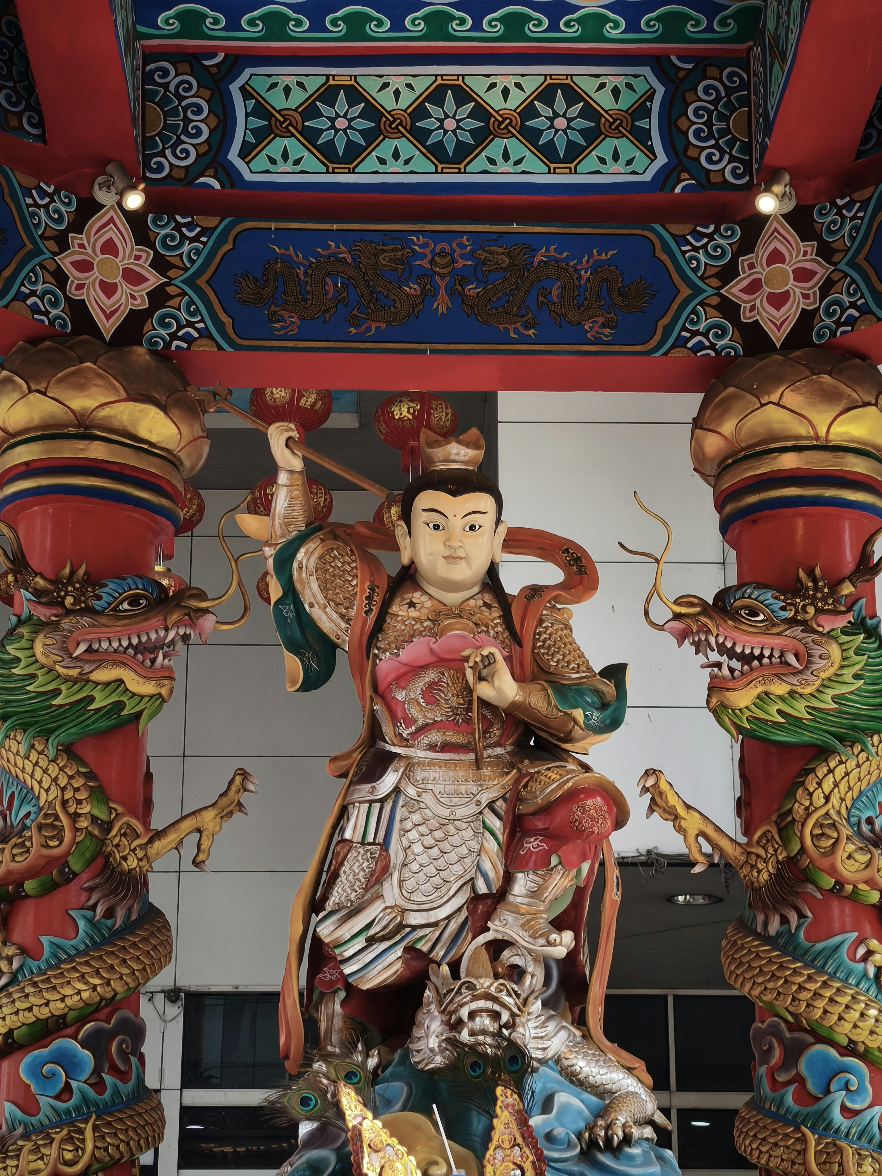 龍の装飾と武将の像が並ぶ寺院の門飾り