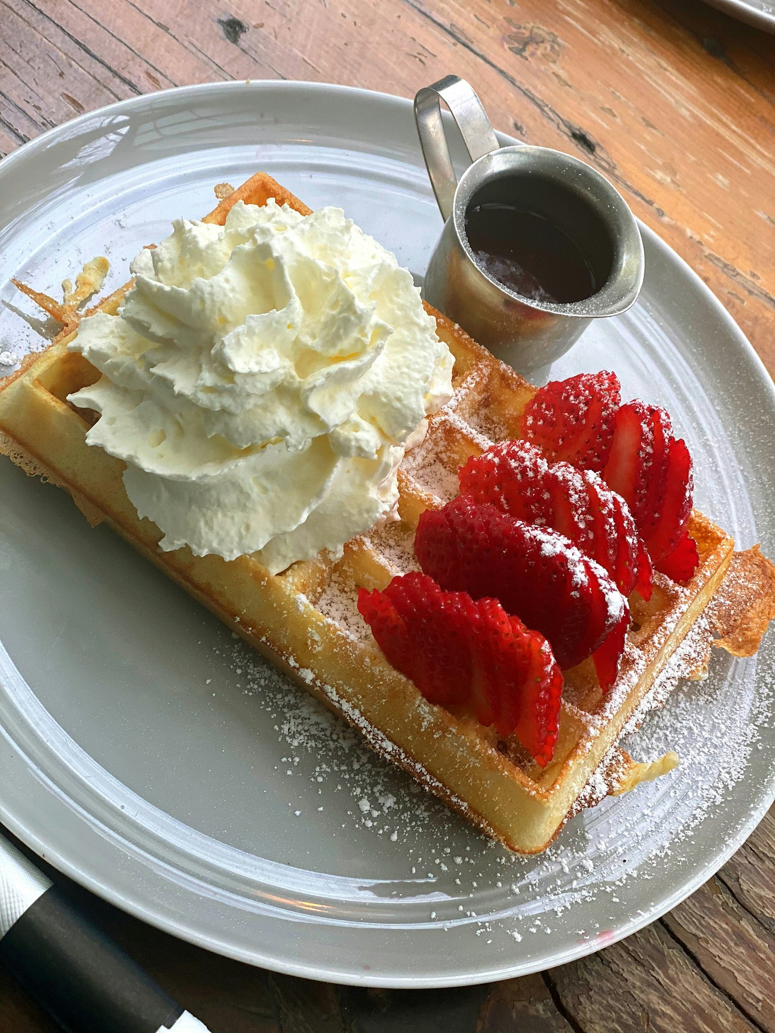 Waffle cubierto con crema batida y fresas