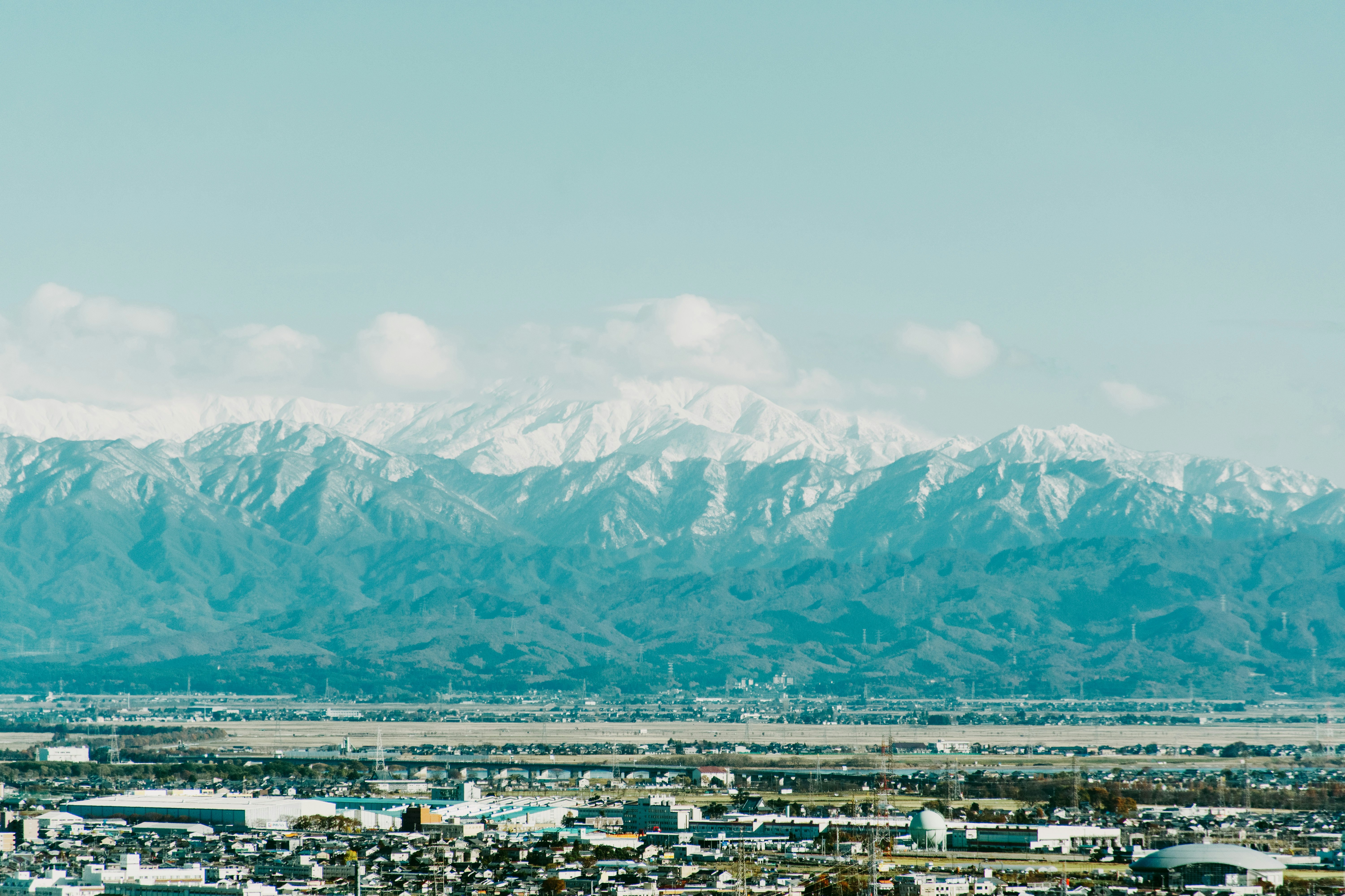 新潟から見える雪を被った山並みと青空の風景