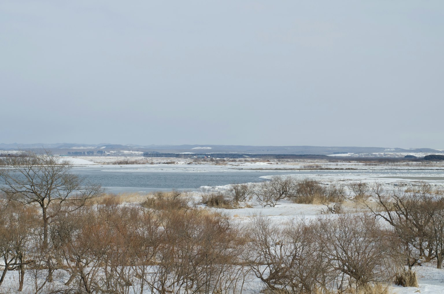 Snow-covered landscape with a tranquil lake view
