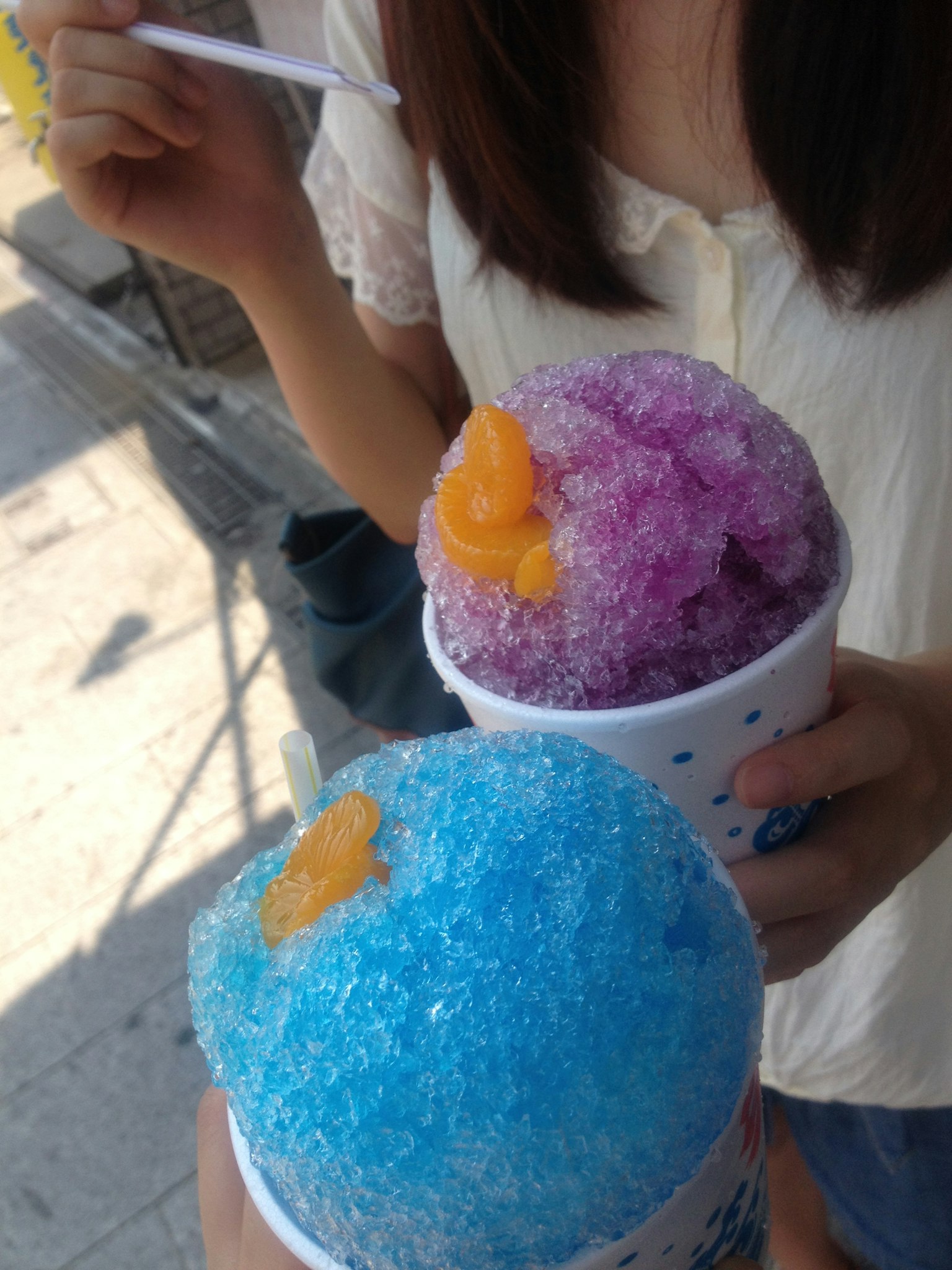 Purple and blue shaved ice topped with orange syrup