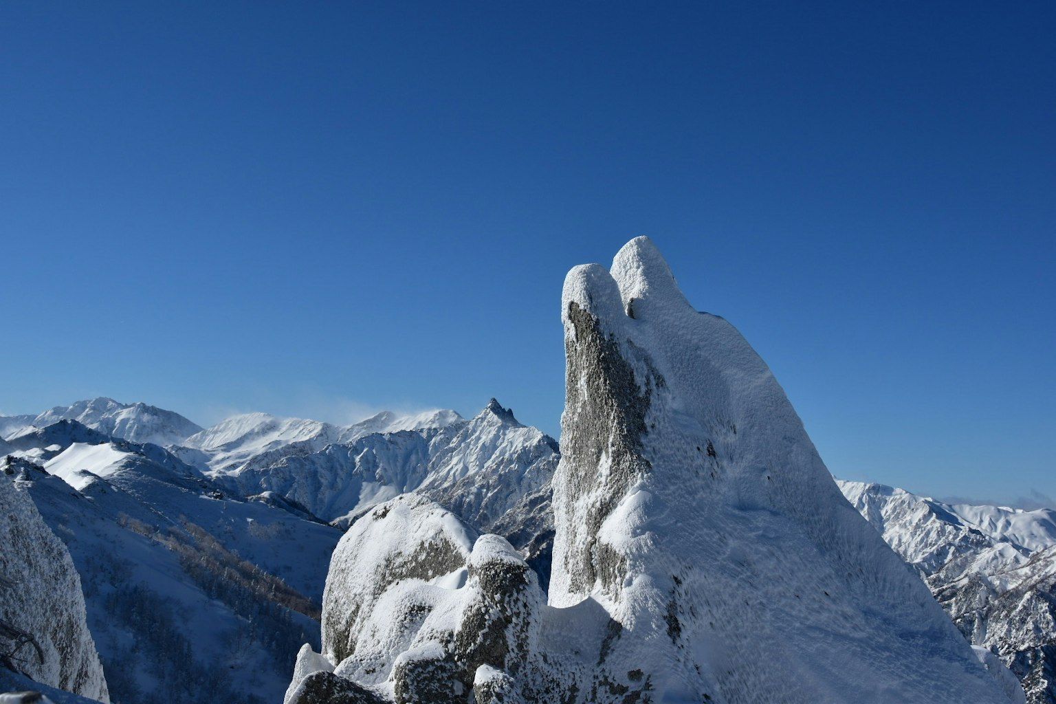 Snow-covered mountains under a clear blue sky