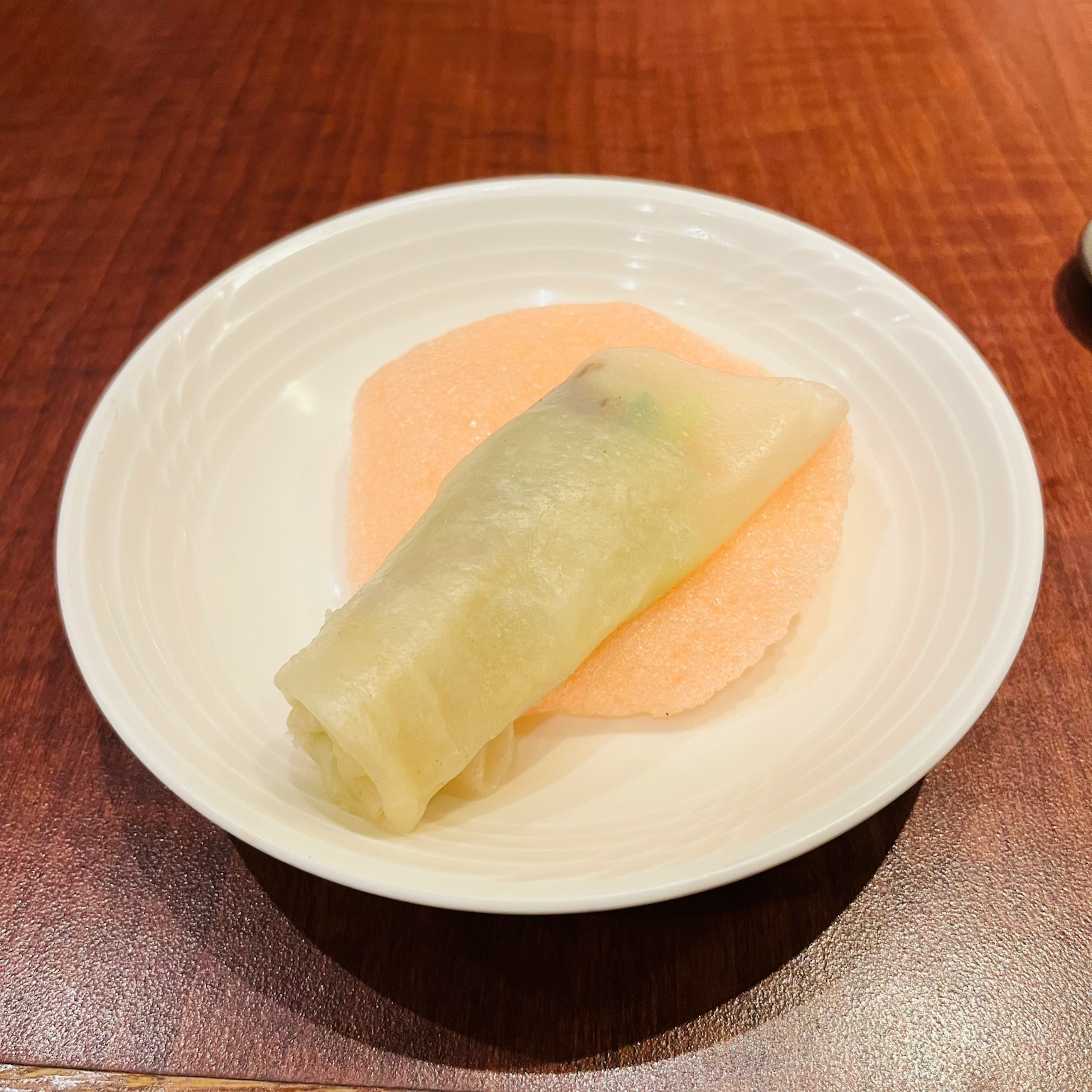 盘子上的春卷和浅粉色的外皮