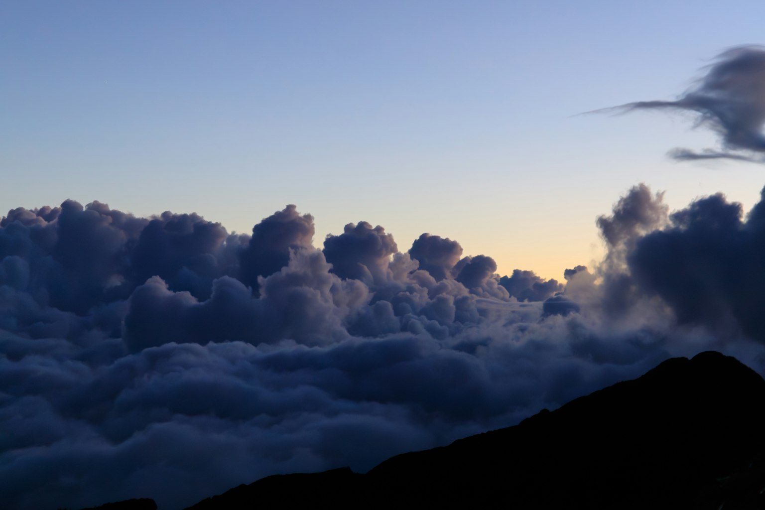 Schöne Sonnenuntergangsansicht über den Wolken mit dunkler Bergsilhouette