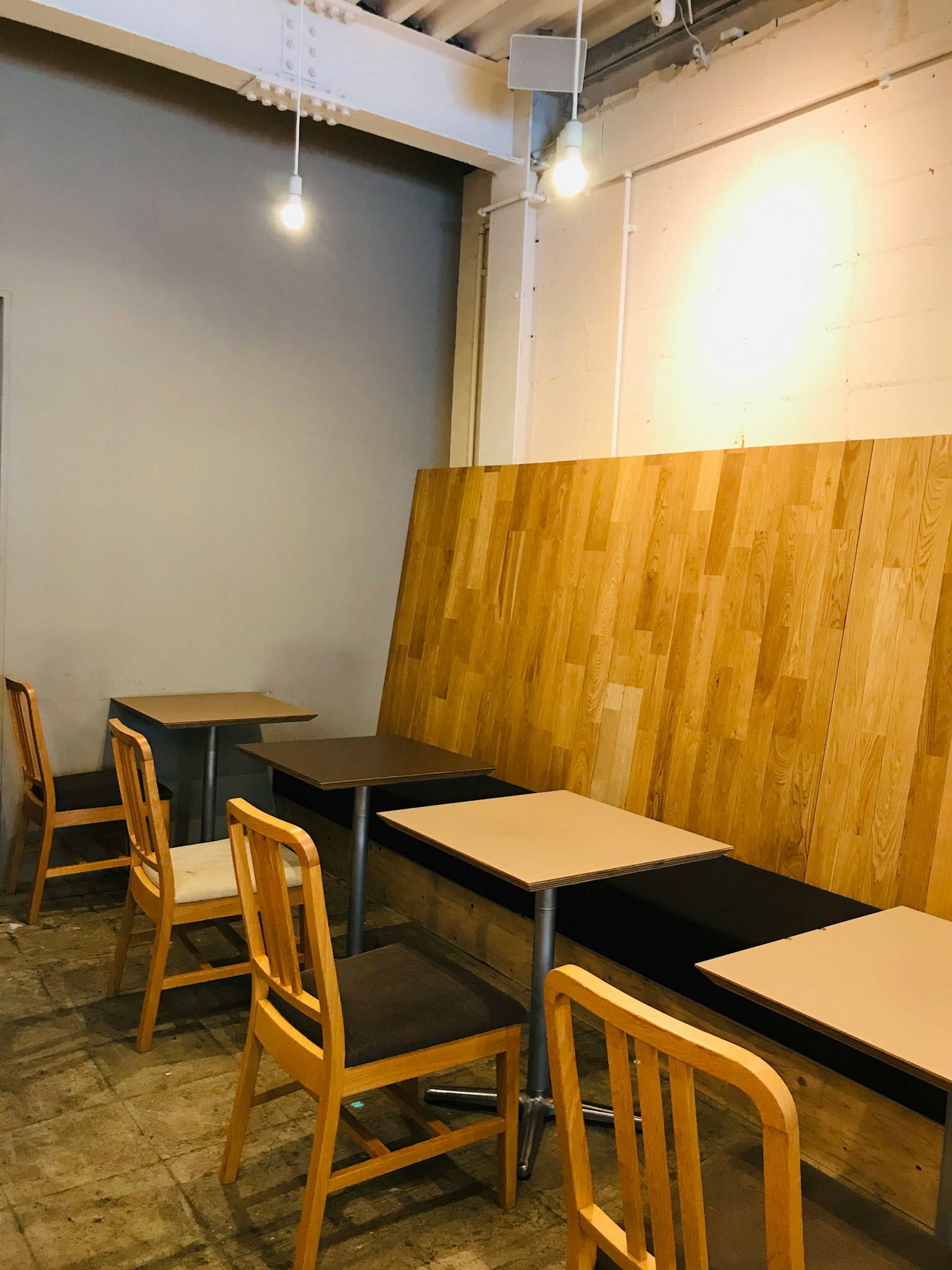 Interno di caffè semplice con tavoli e sedie in legno illuminazione brillante