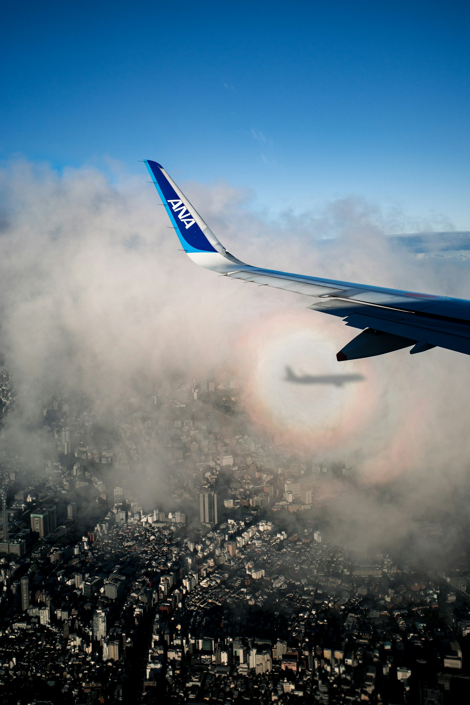 Vue d'une aile d'avion avec un halo arc-en-ciel dans les nuages