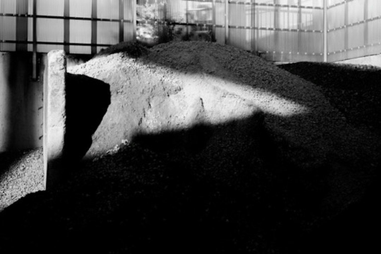 A striking image of a gravel mound with contrasting shadows in black and white