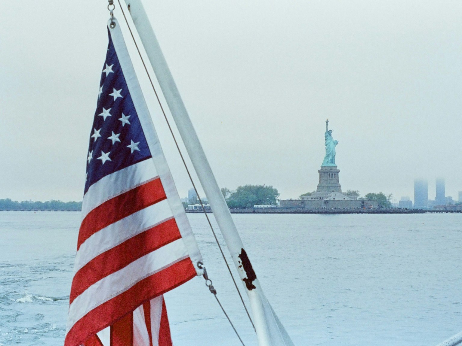 Bendera Amerika dengan Patung Liberty di latar belakang